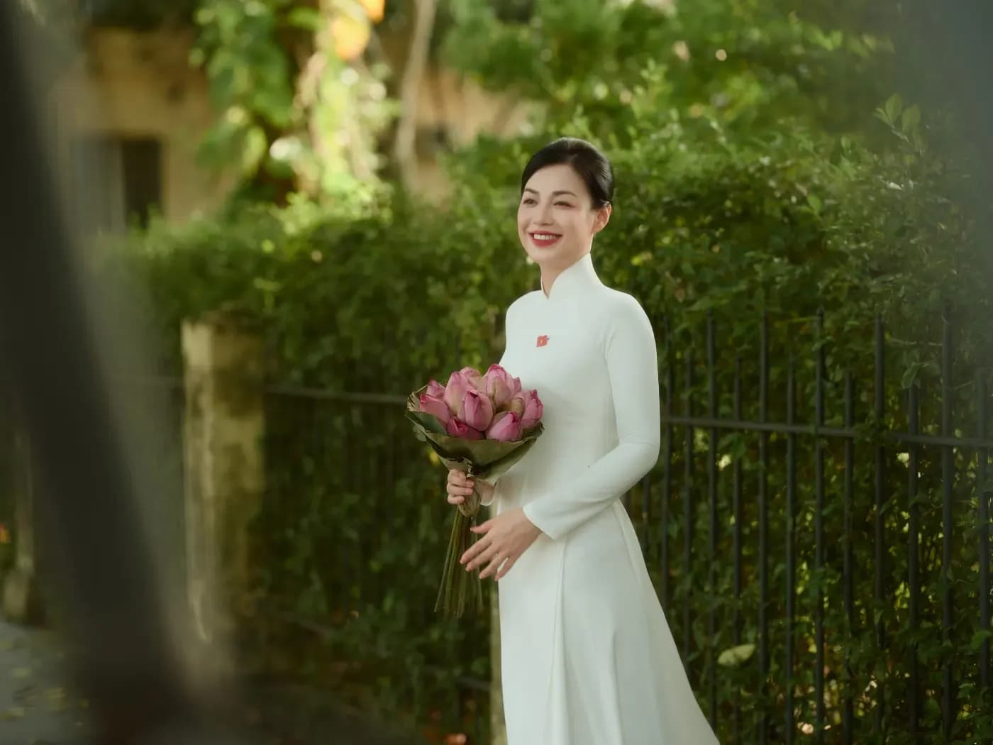 Áo dài trắng trong bối cảnh cây xanh cho outfit chụp ảnh mùa thu