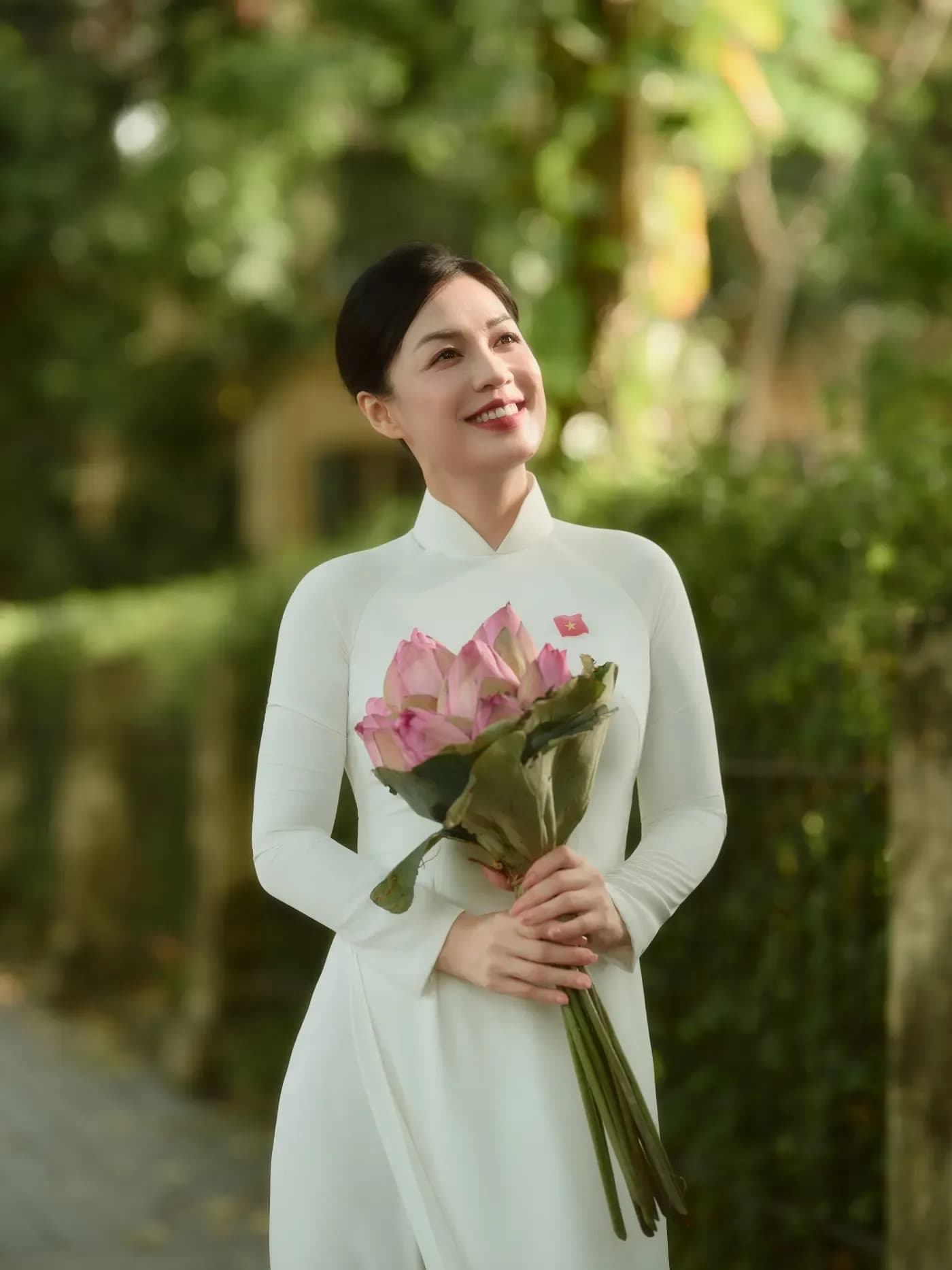 Áo dài trắng cầm hoa nhỏ cho concept mùa thu Hà Nội