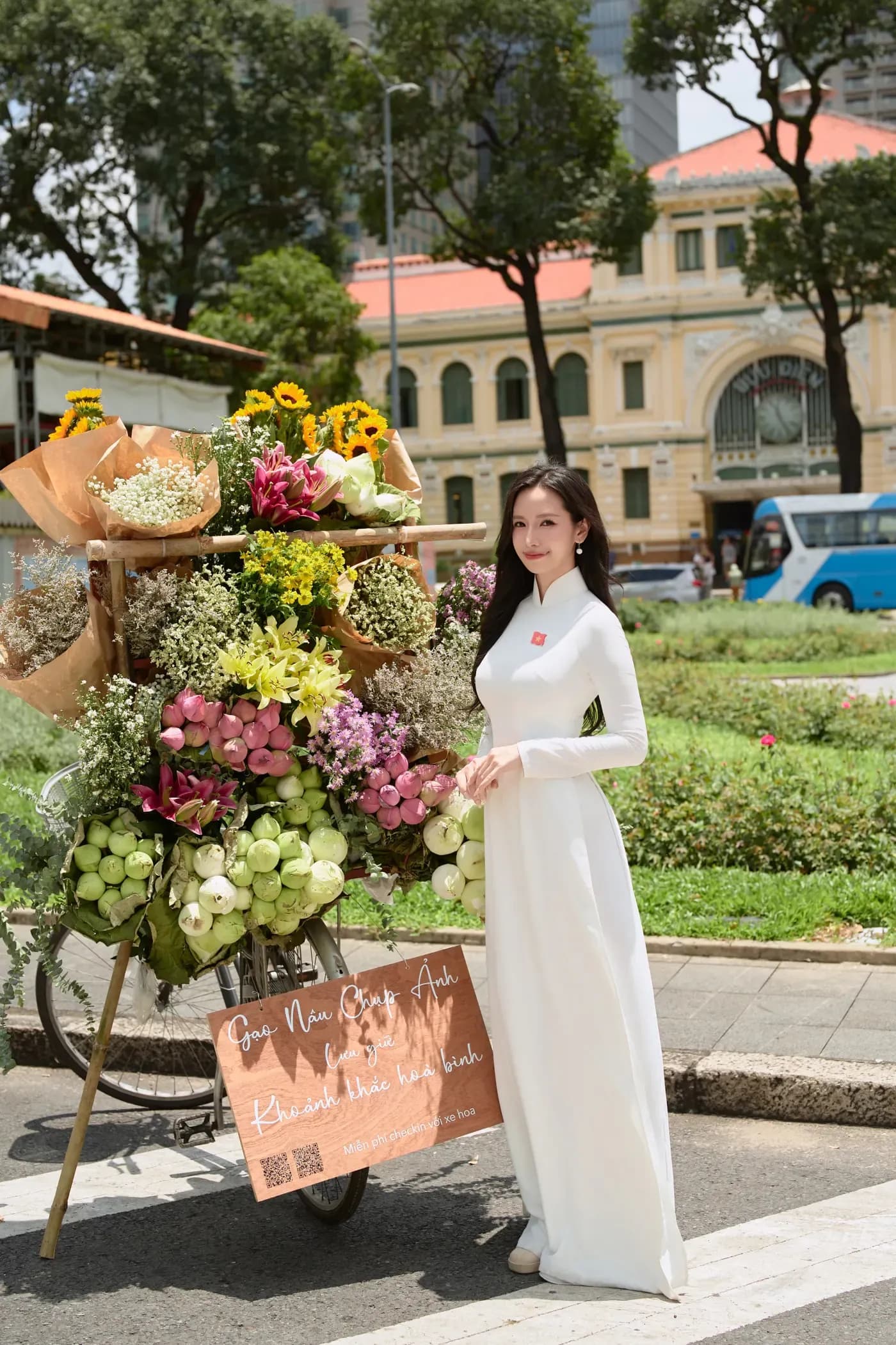 Thiếu nữ áo dài trắng chụp ảnh mùa thu Hà Nội cạnh xe hoa