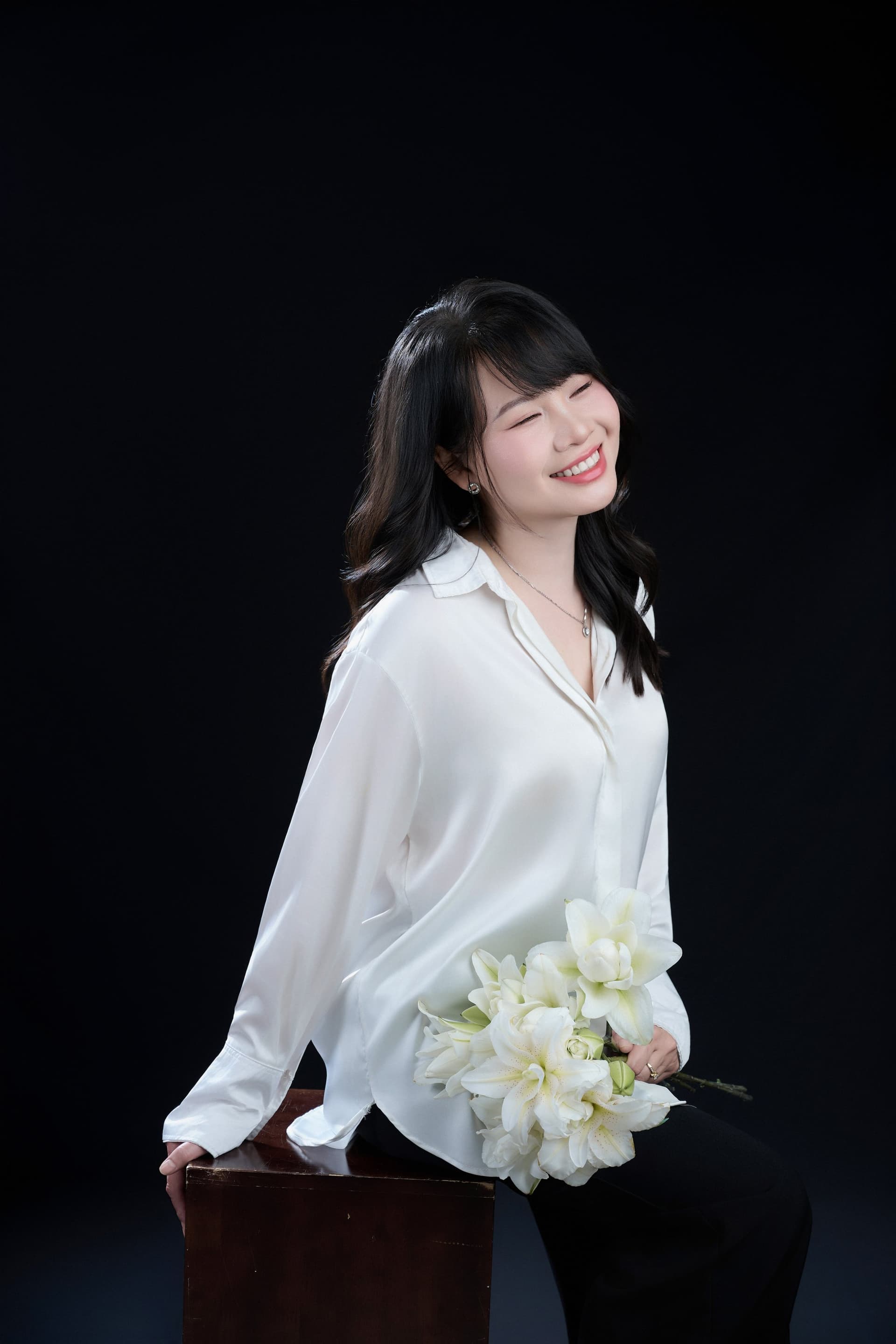 Ngọc Huyền cười khúc khích, ôm bó loa kèn trắng vào lòng — khoảnh khắc một người đàn bà hai mươi sáu tuổi, đột ngột hiểu một câu nói của bố từ năm 1998.