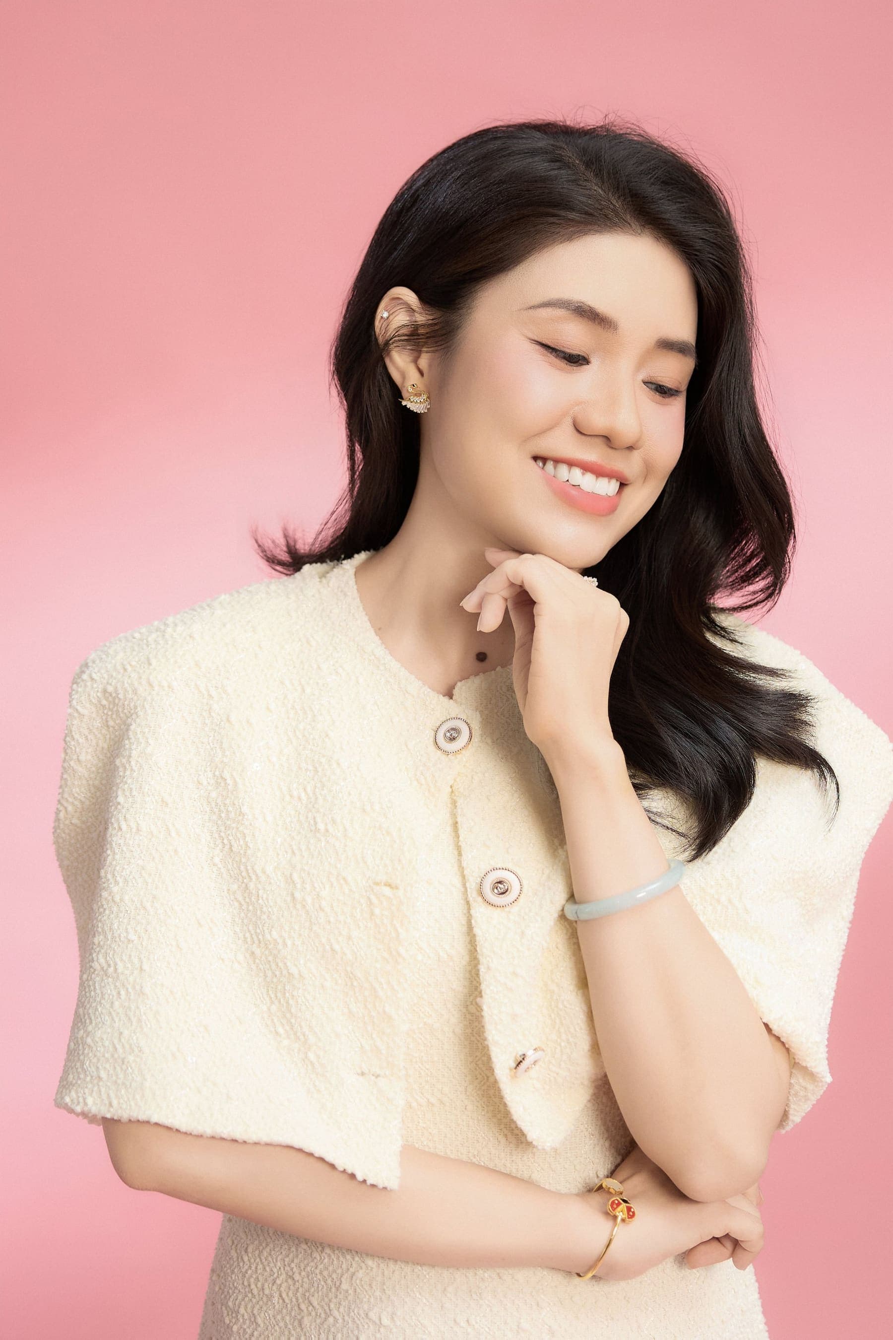 Người phụ nữ ngồi tựa nhẹ, chống cằm, ánh mắt suy tư, gương mặt mang nét lặng của những ngày dài giữ nhà cho ổn