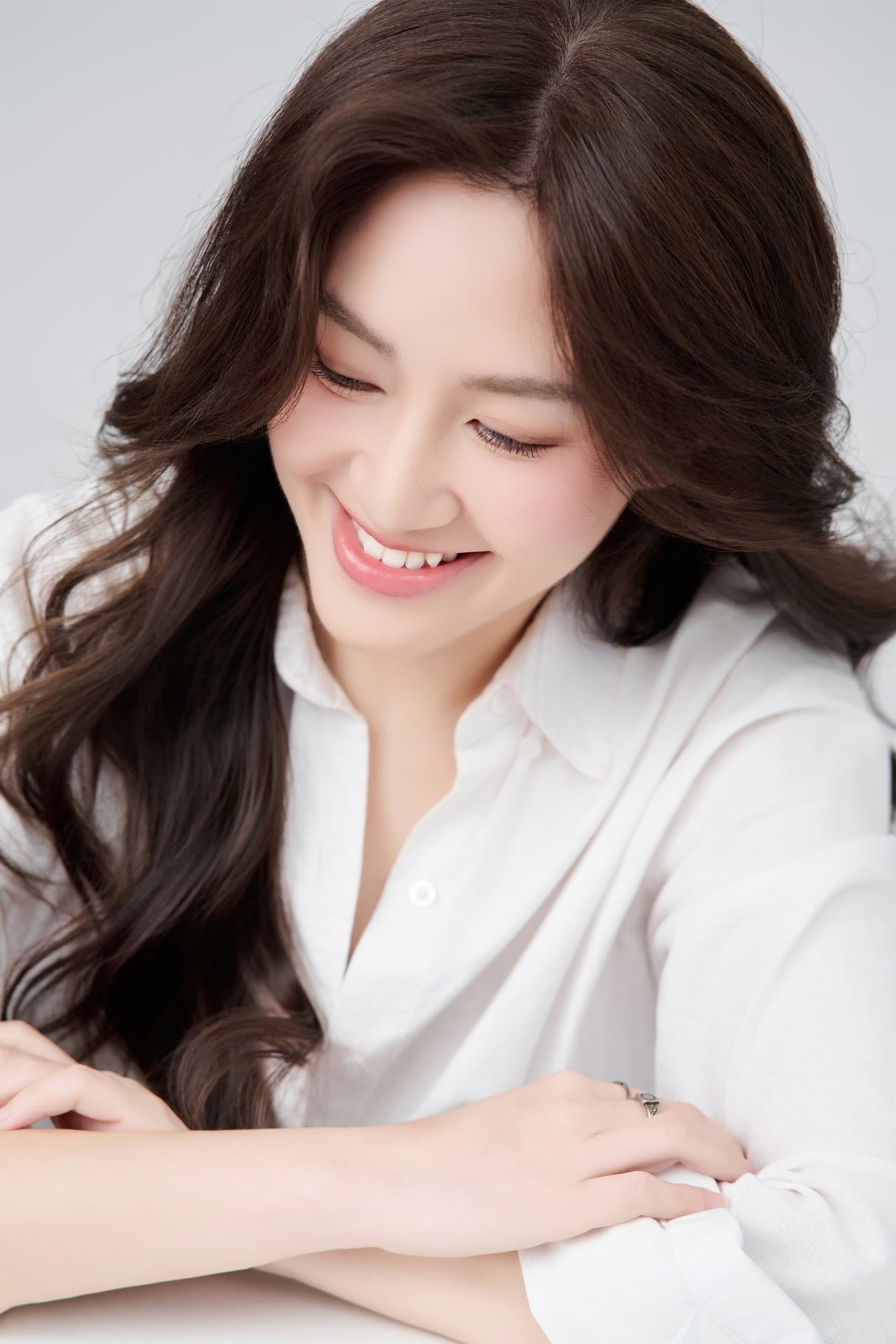 Chị Vân Võ mỉm cười nhẹ nhàng nhìn nghiêng trong chiếc sơ mi trắng tinh tế