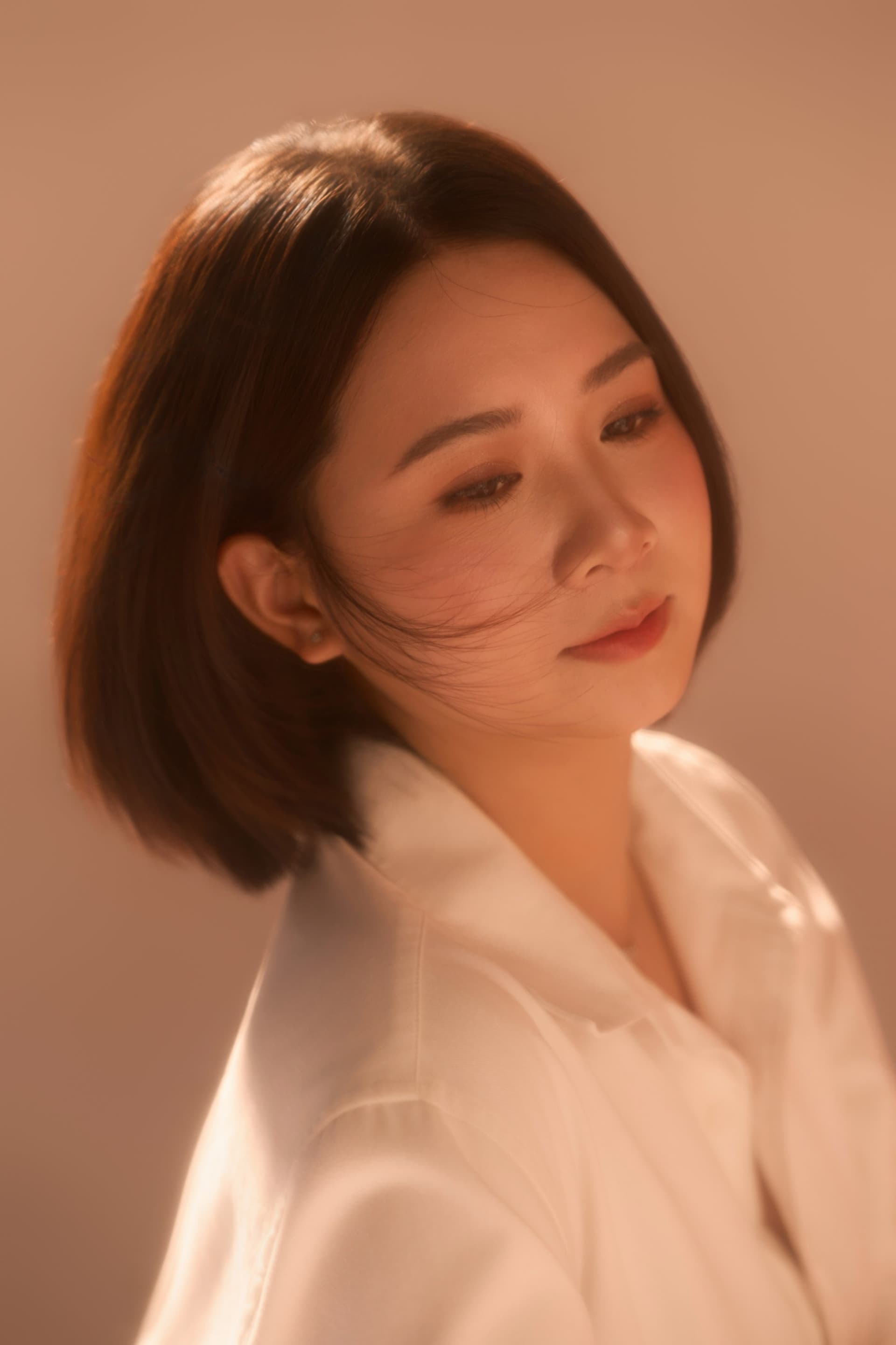 Chị Vũ Hậu với ánh mắt trầm tư tĩnh lặng đầy suy nghĩ, bối cảnh ấm áp dịu dàng