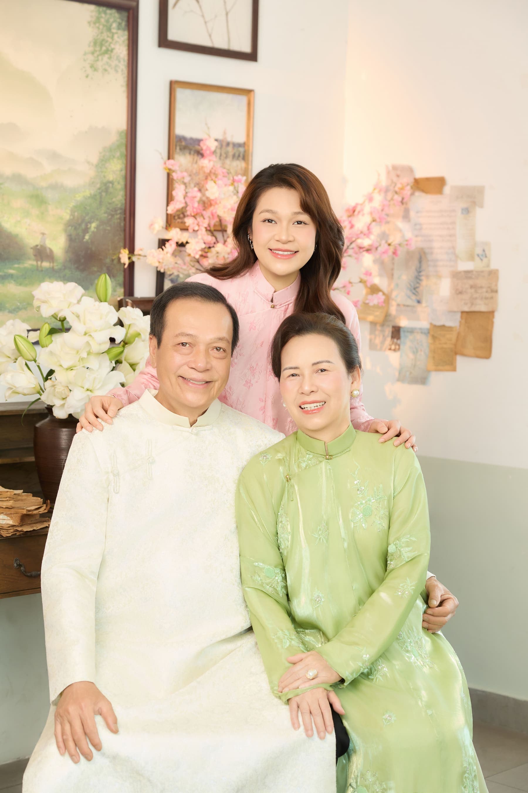 Cha mẹ và con gái ngồi gần nhau trong áo dài, nụ cười sum vầy của tháng Năm