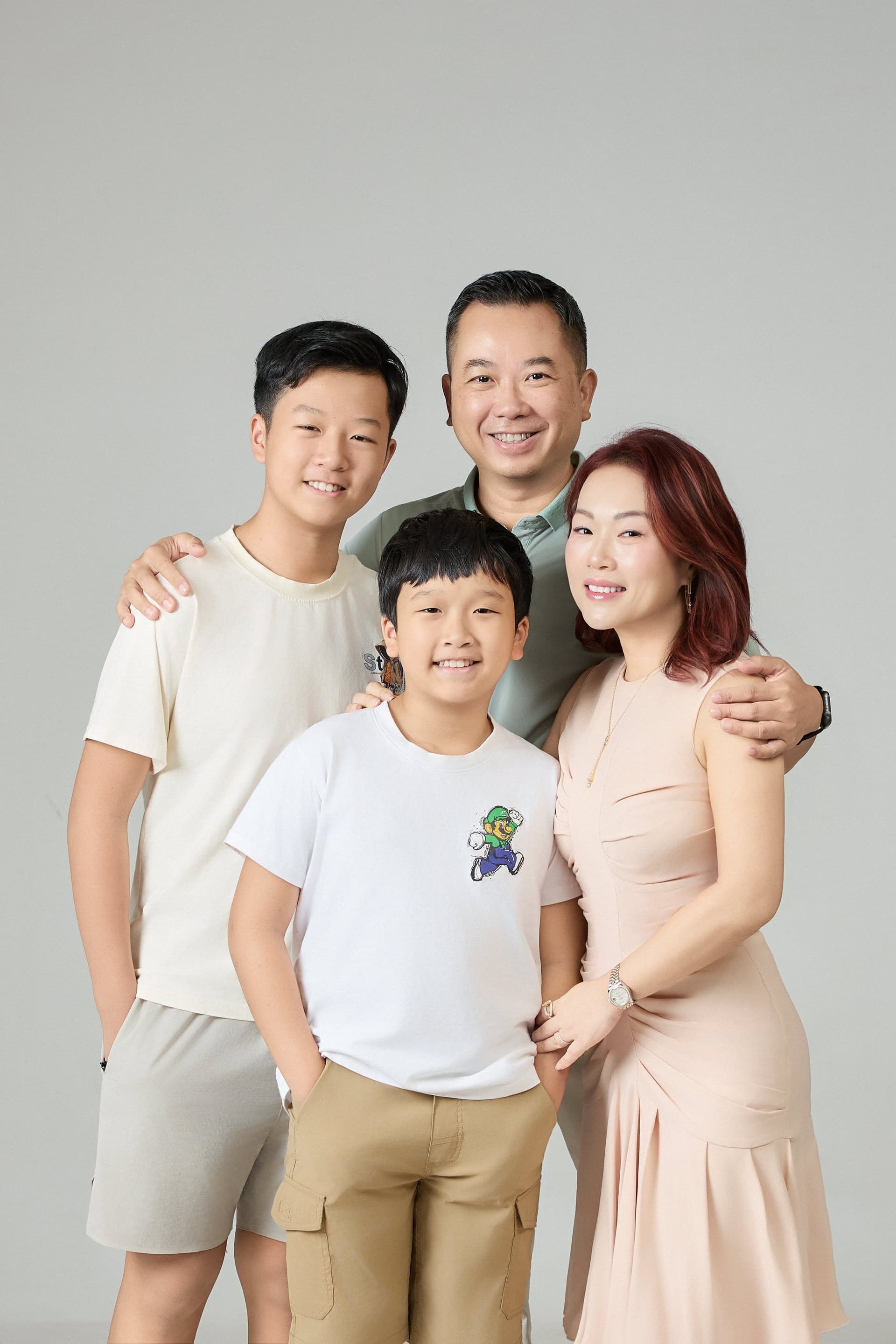Gia đình ba thế hệ — bà ngoại, bà nội, vợ chồng, một thằng bé năm tuổi ngồi giữa hai bà — lần đầu sau bảy năm cả nhà ngồi cùng nhau