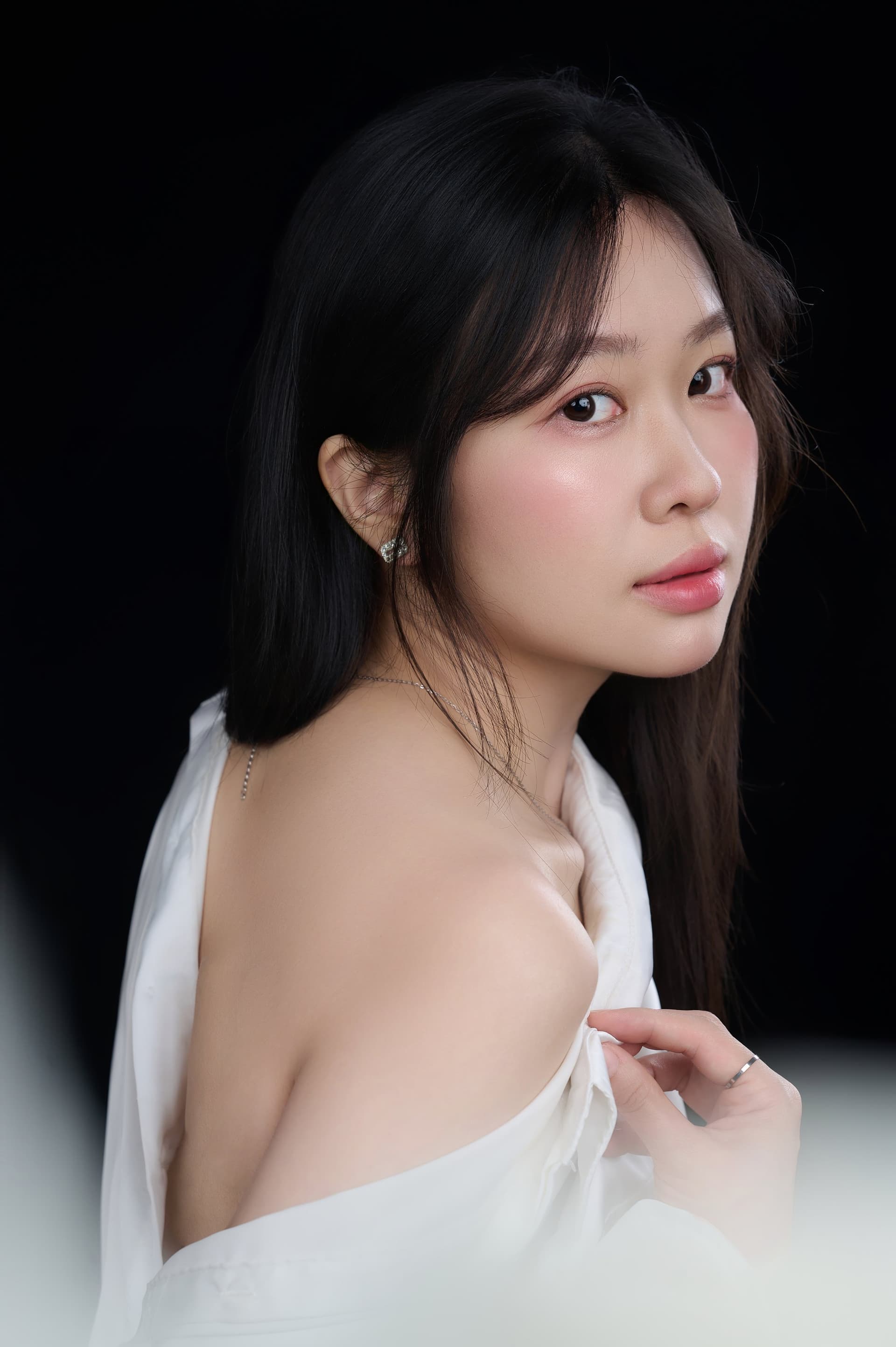 Chân dung nghiêng, người phụ nữ áo trắng, gương mặt sáng tự nhiên — sự dịu dàng còn nguyên giữa đời sống bận