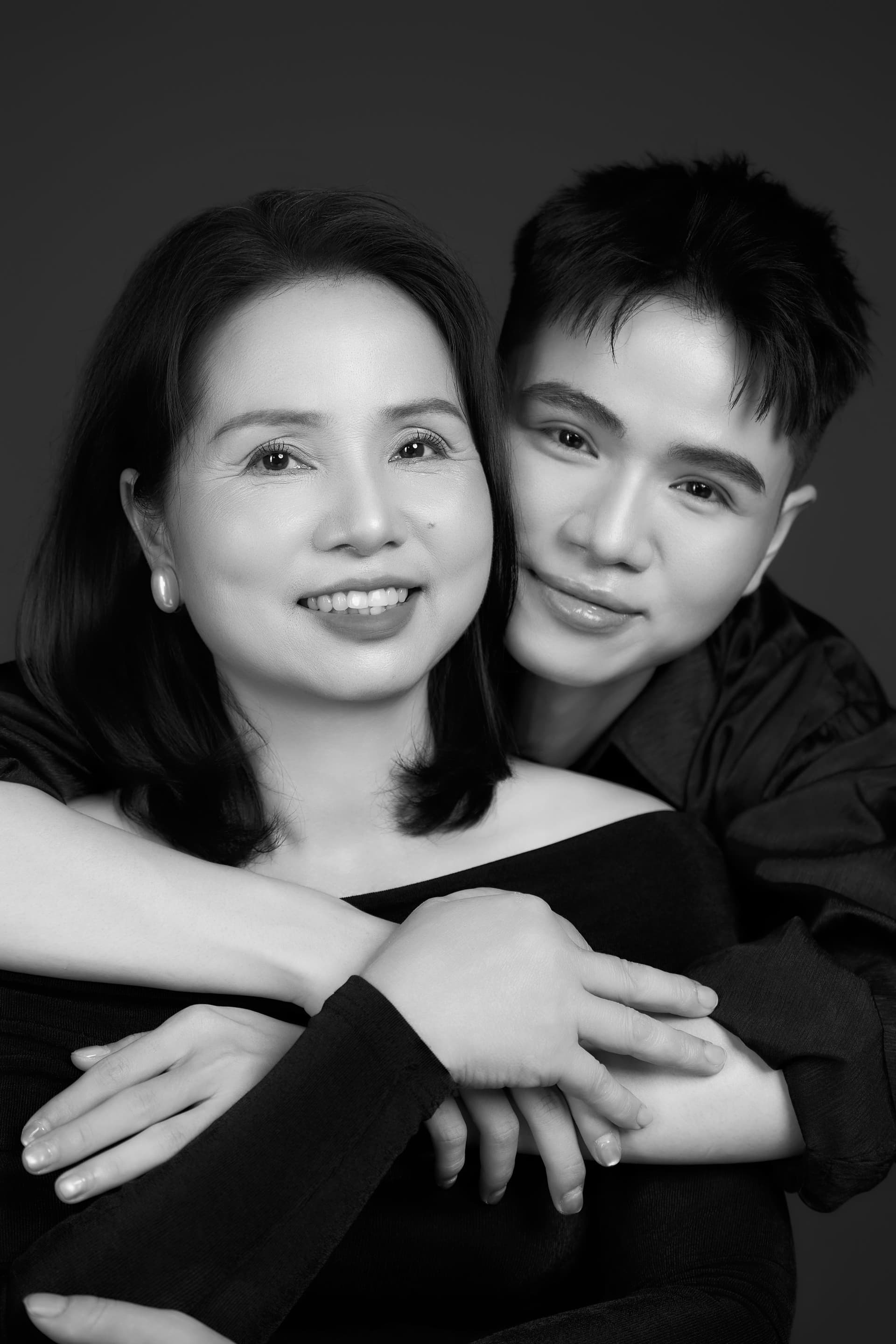 Con trai ôm mẹ từ phía sau lưng, cả hai mẹ con mỉm cười ngập tràn niềm vui hạnh phúc