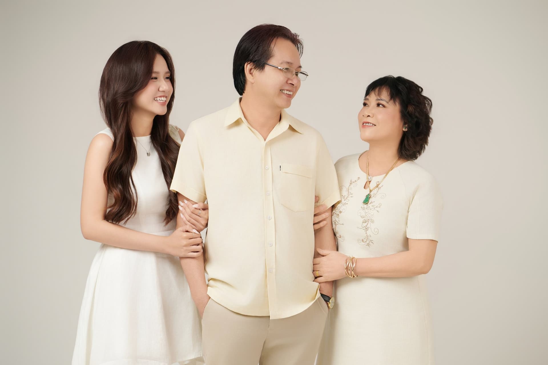 Cận cảnh người đàn ông trung niên đeo đồng hồ dây da đen ở cổ tay, tay đặt trên vai con gái — cử động đã quen từ những năm con vào cấp ba