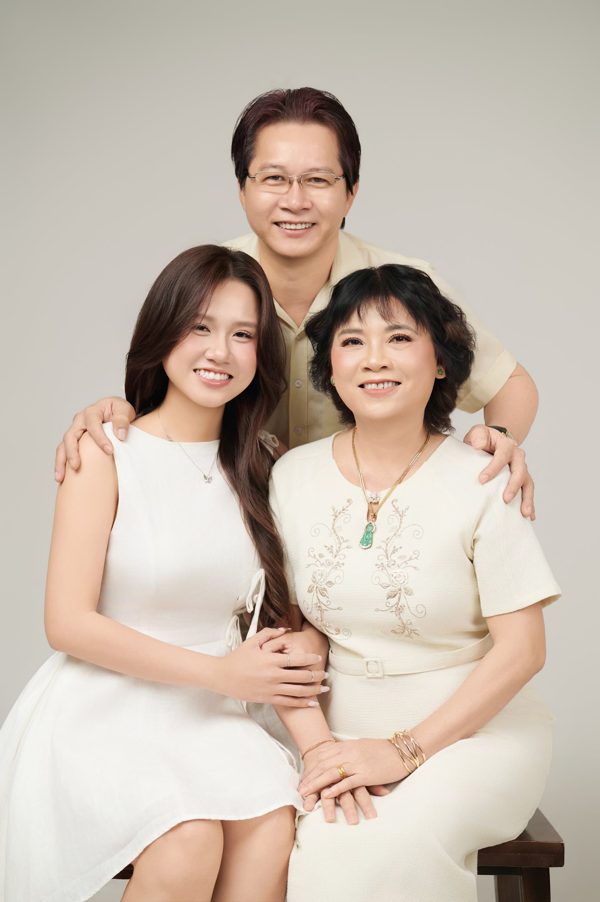 Người đàn ông trung niên với vài sợi muối ở chân tóc, biểu cảm trầm, mỉm cười nhẹ — những sợi mà con chưa từng thấy hồi mười sáu