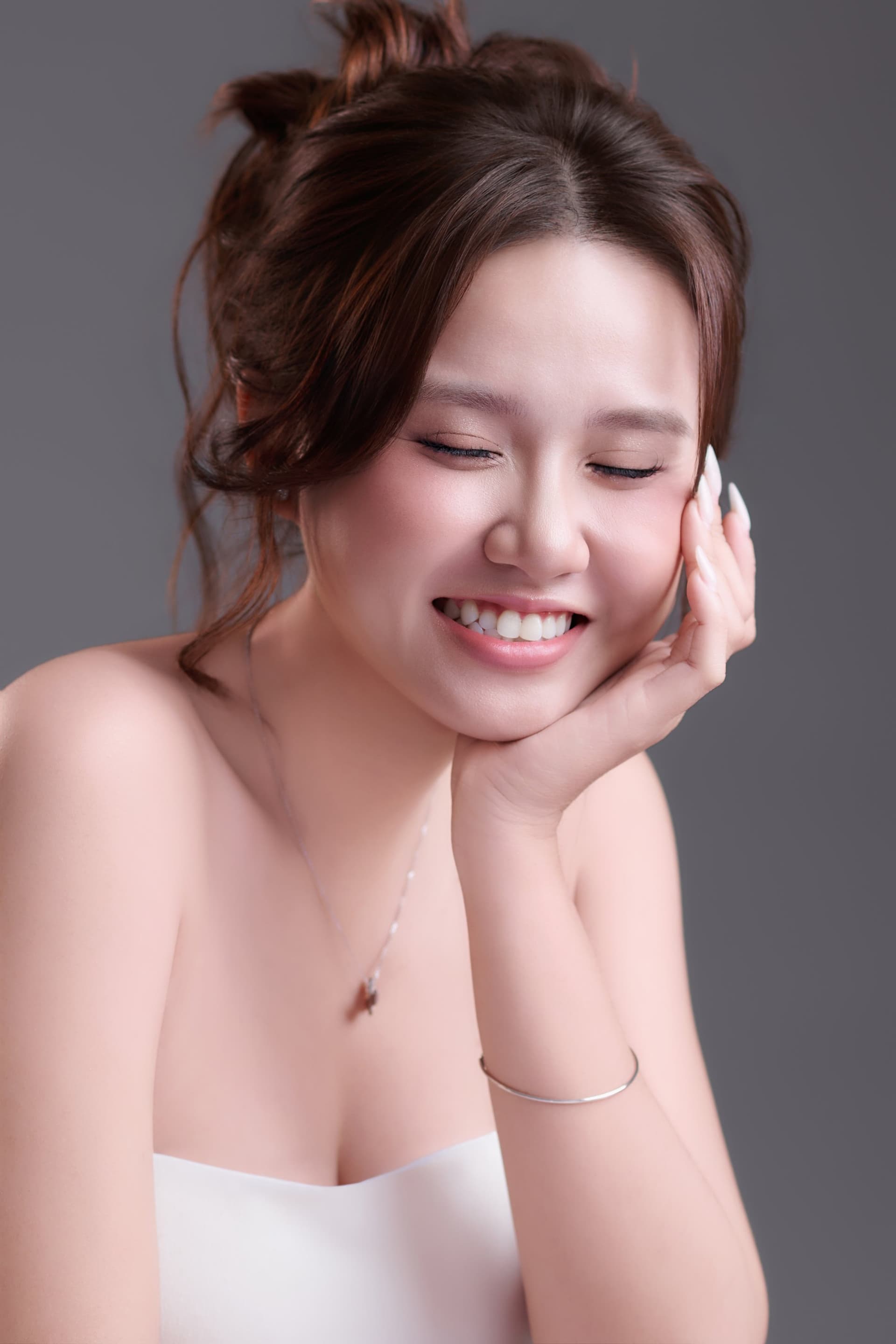 Cả ba người đứng giữa khung hình — ba quàng vai con, mẹ ôm cánh tay ba — cái đồng hồ vẫn đang chạy trên cổ tay người đàn ông tóc đã hơi muối