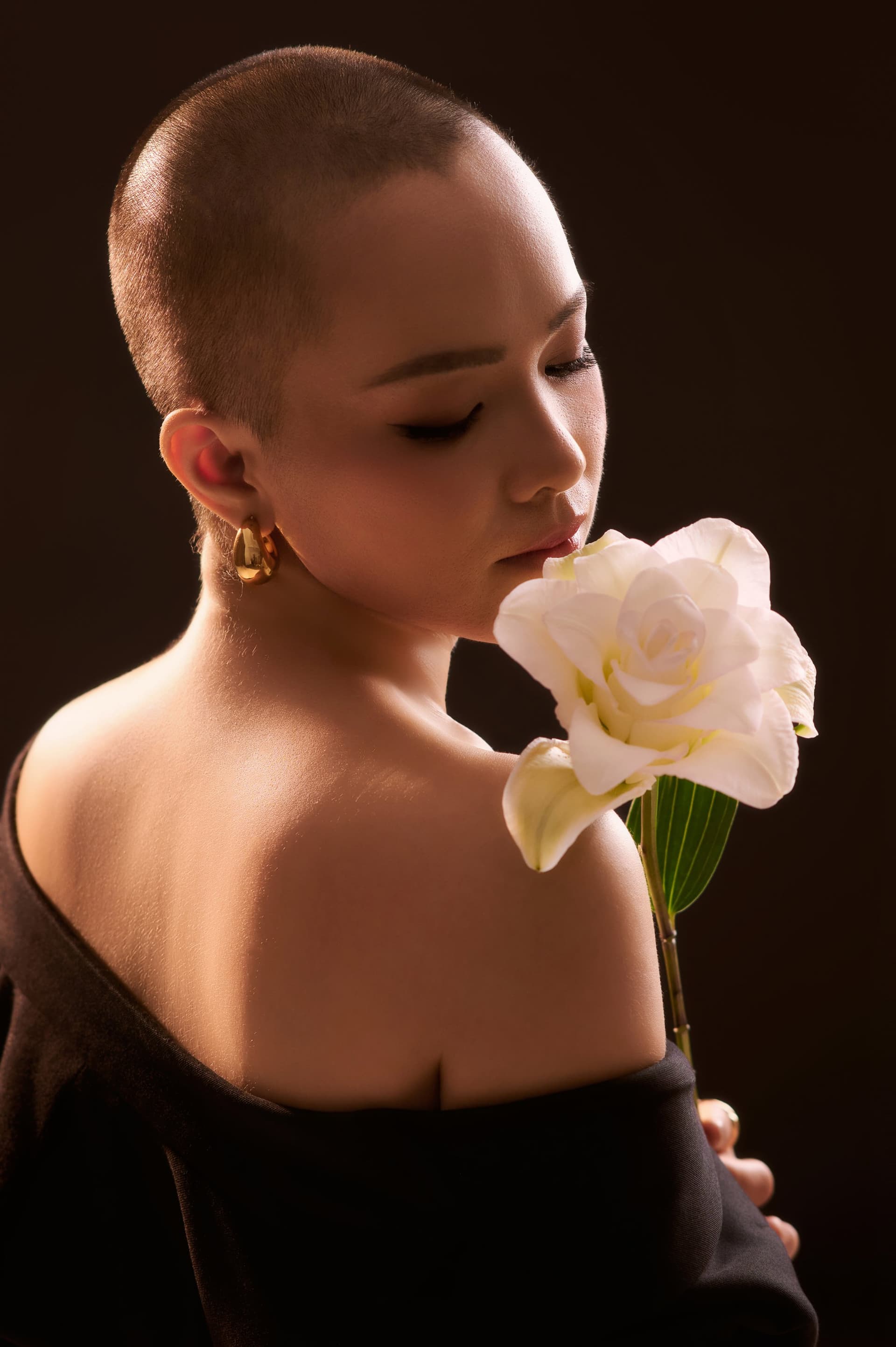 Diệu Huyền nhắm mắt nhẹ, ngả người gần bông loa kèn trắng.