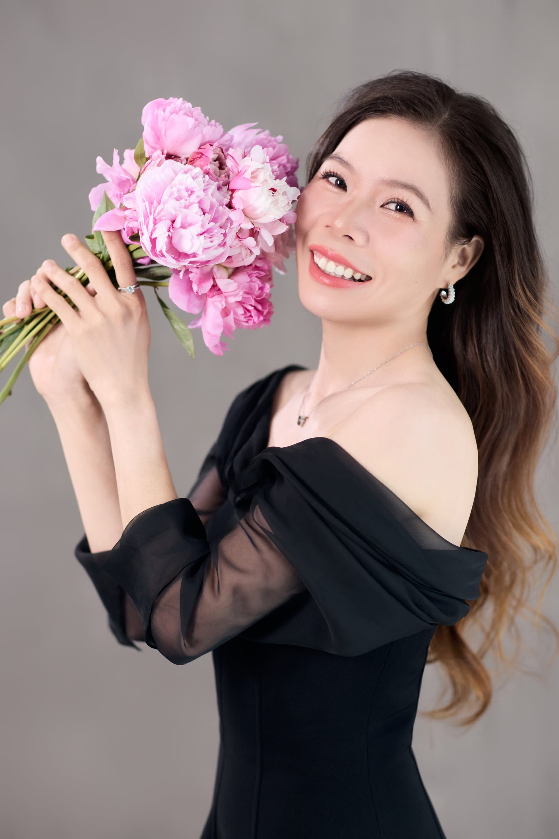 Chị Thủy đứng cầm bó hoa, dáng tự tin — khoảnh khắc giữ lại mình ở tuổi này