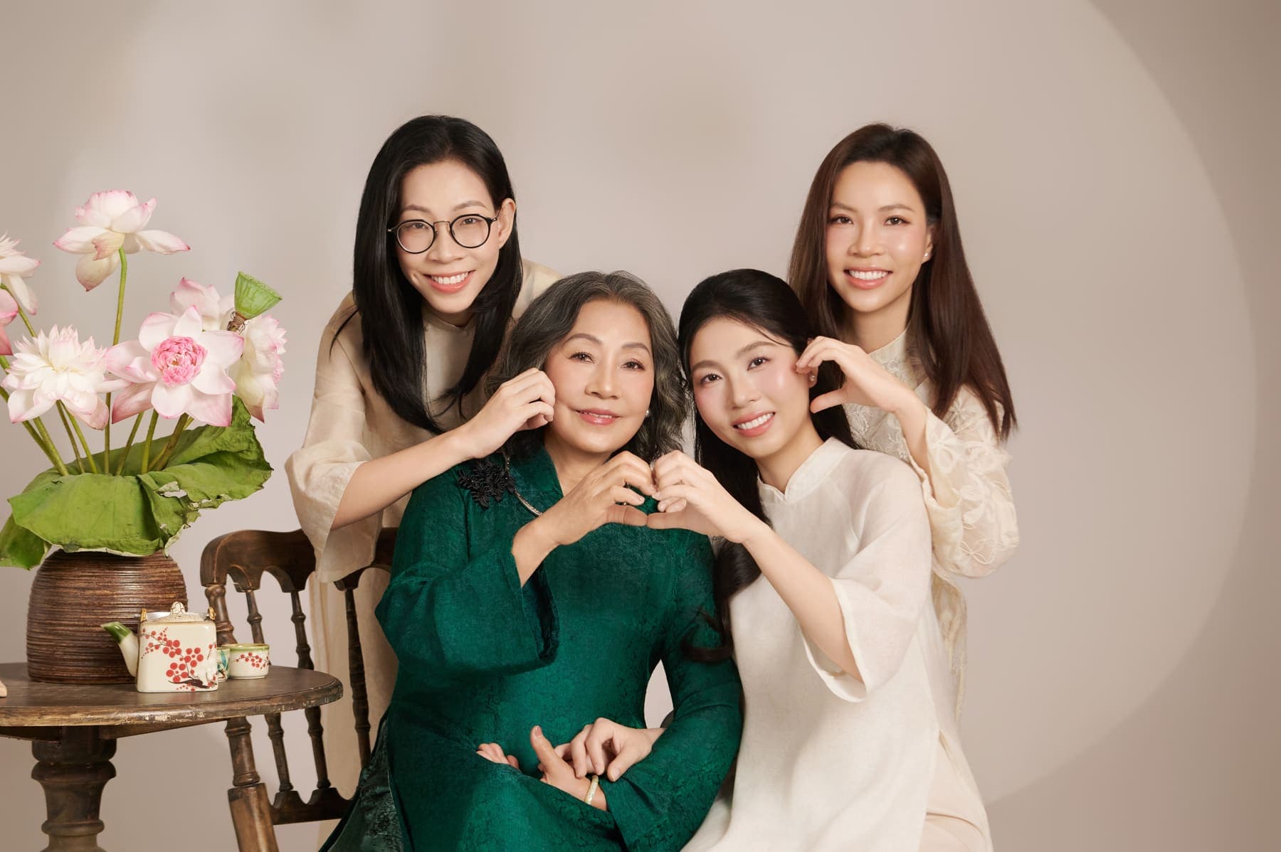 Người mẹ áo xanh được ba cô con gái tựa quanh, nụ cười đủ đầy của phần lời đẹp nhất