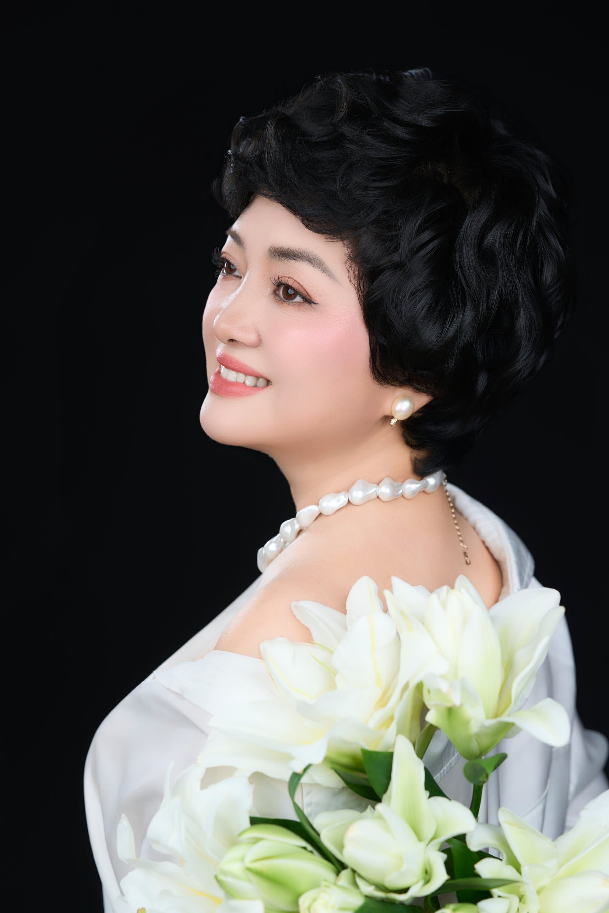 Góc nghiêng thần thái của chị Trần Thị Kim Nhung diện sơ mi trắng khẽ mỉm cười đầy tự tin và tươi tắn