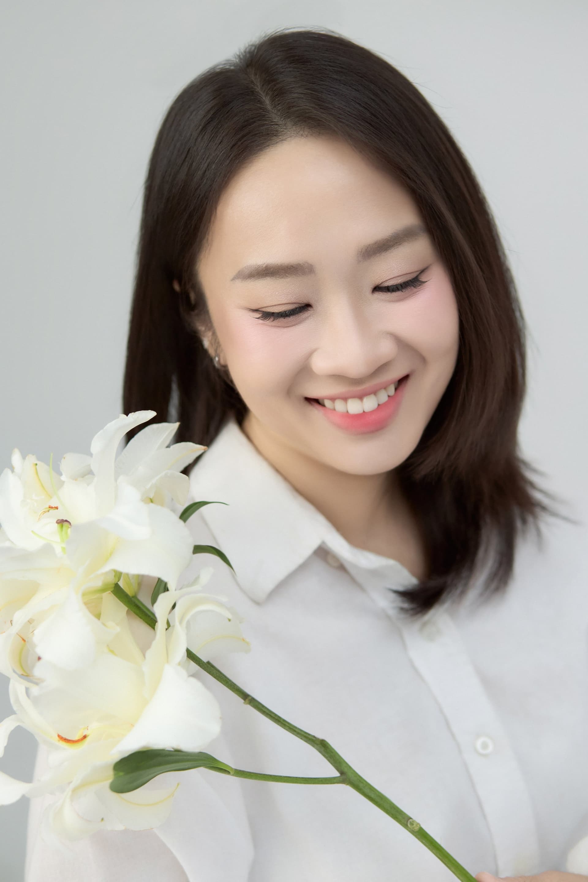 Trâm ôm bó hoa lily trắng cuống dài, áo sơ mi trắng — kỷ niệm cô muốn giữ lại cho riêng mình trong quãng này