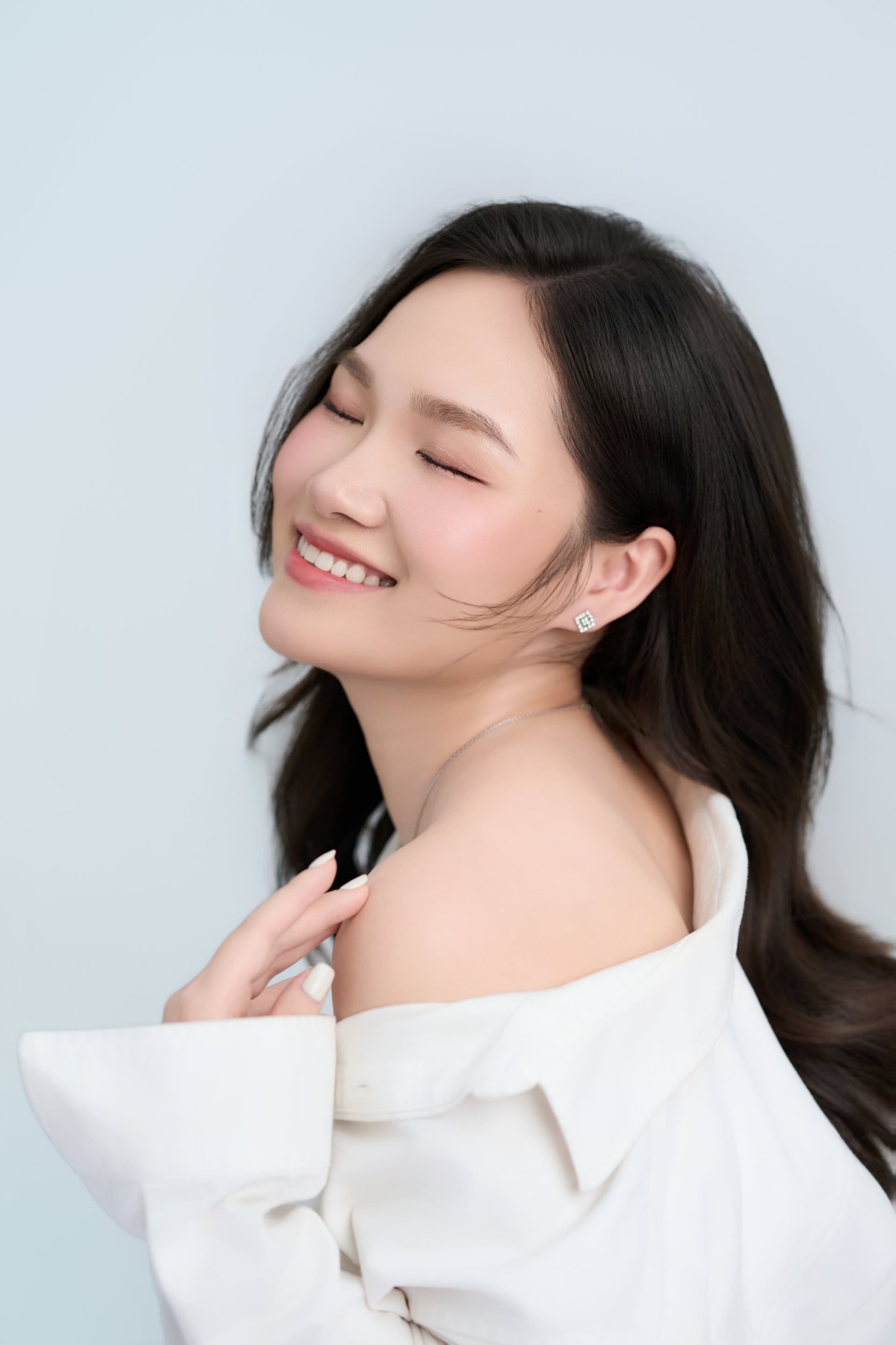 Người phụ nữ áo trắng nhìn xuống trầm tư, nét mặt dịu — một khoảng lặng giữa ký ức ngày cưới chưa trọn vẹn