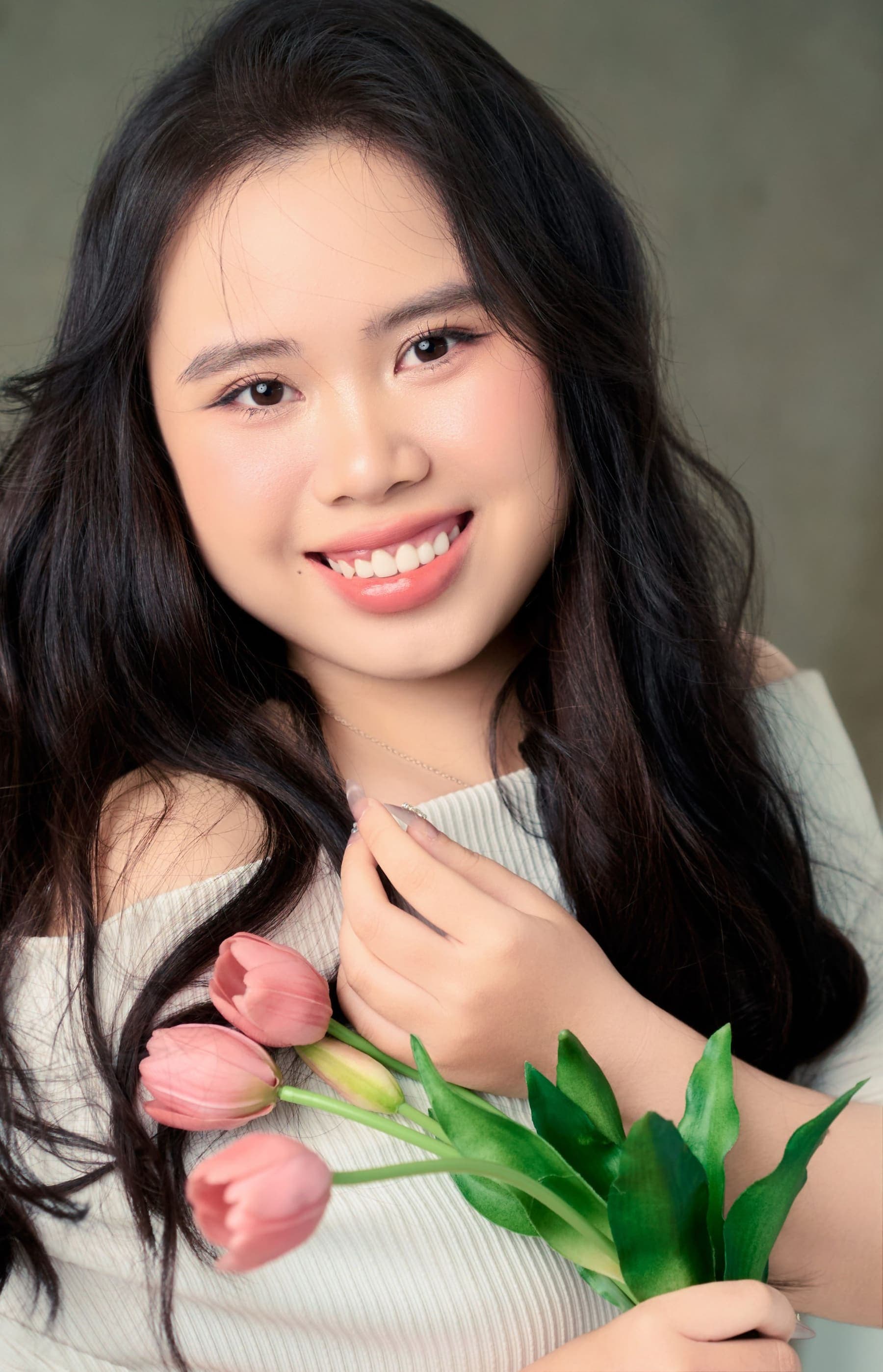 Chân dung cô gái ôm bó tulip, ánh mắt cười sáng tự nhiên — nụ cười khiến ngày của người đối diện nhẹ hơn