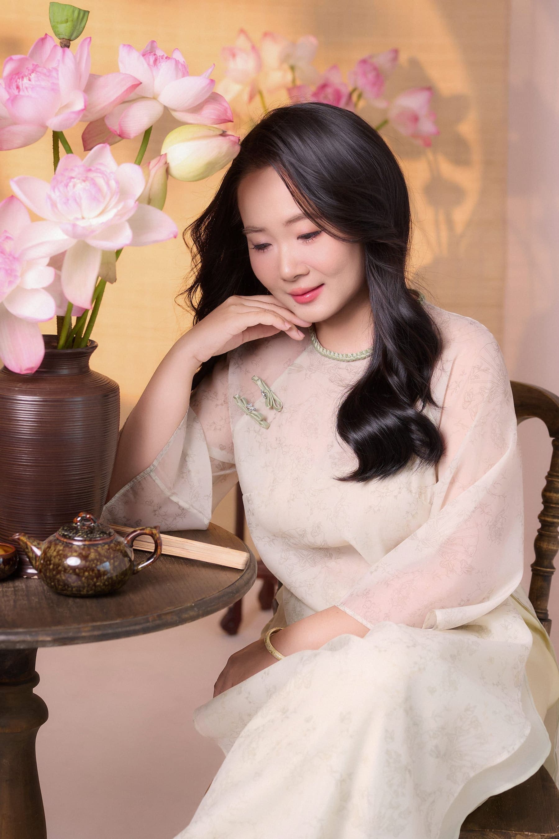 Người phụ nữ tựa tay vào bàn gỗ, ánh nhìn mơ màng, mood dịu mềm