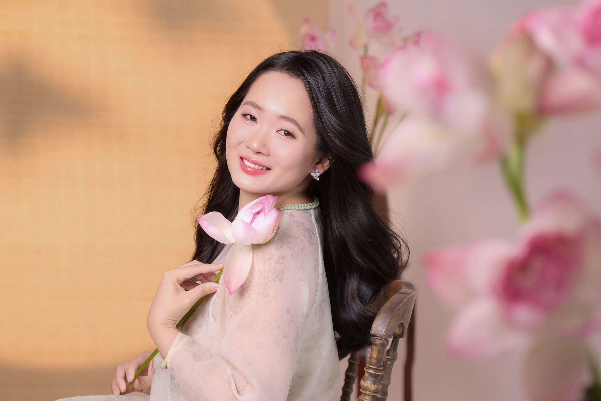 Người phụ nữ áo trắng cầm hoa sen, dáng thanh thoát, mood nở ra dịu dàng