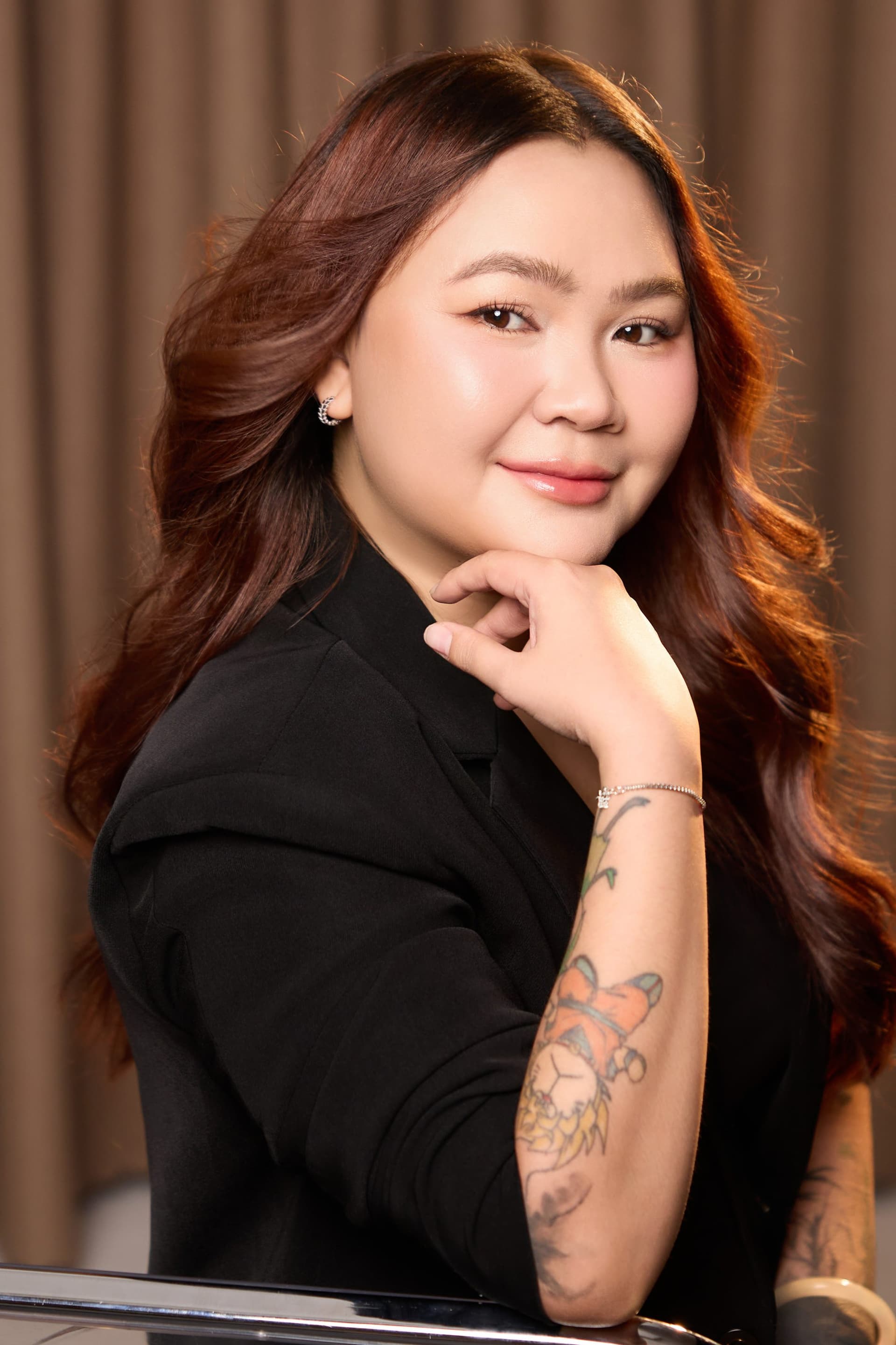 Lily Nguyen tựa cằm lên tay, ánh mắt bình yên nhìn thẳng đầy tự nhiên.