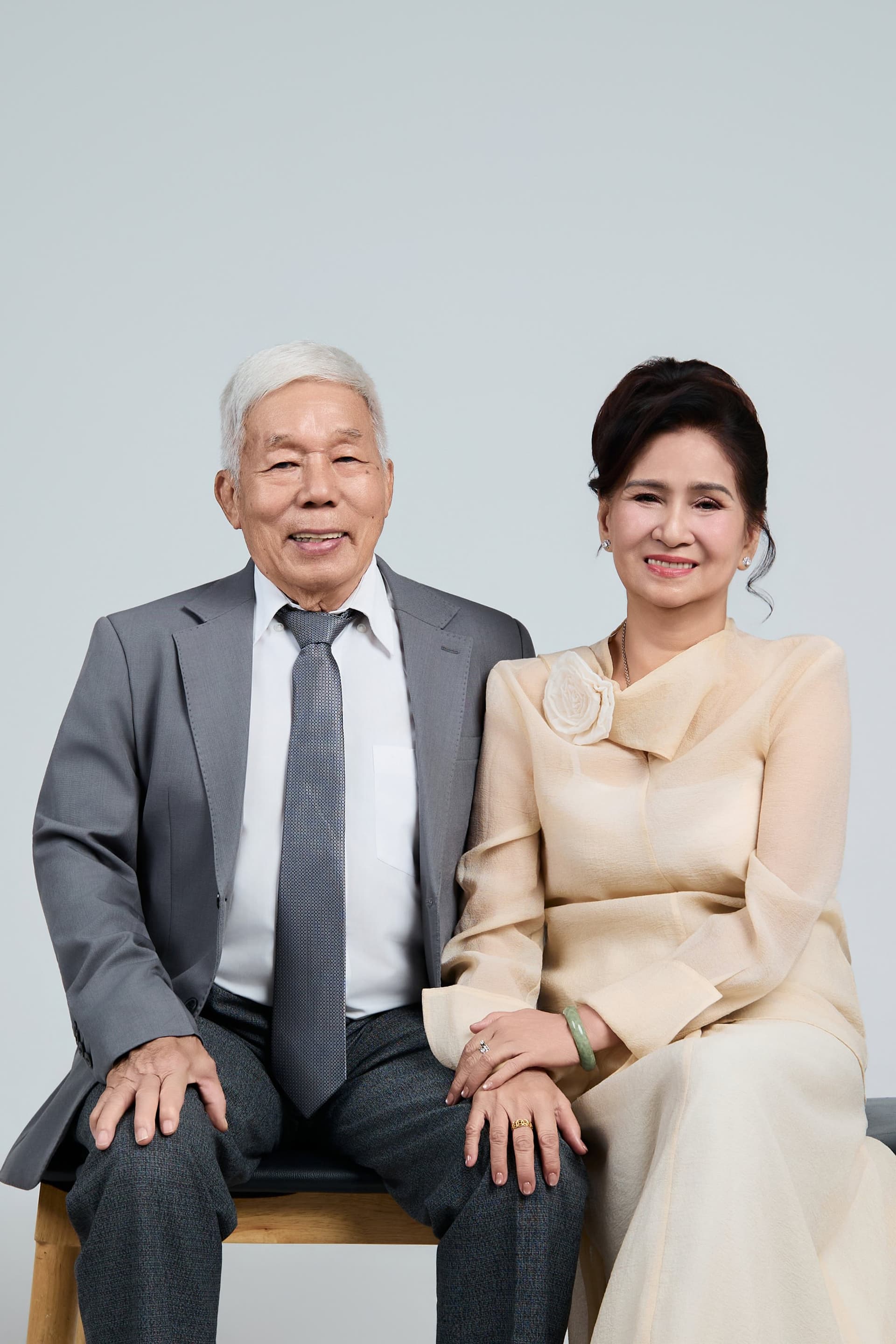 Ông bà ngồi bên nhau mỉm cười hiền hậu, ghi dấu chặng đường nhiều năm cùng chung bước dưới mái nhà ấm áp