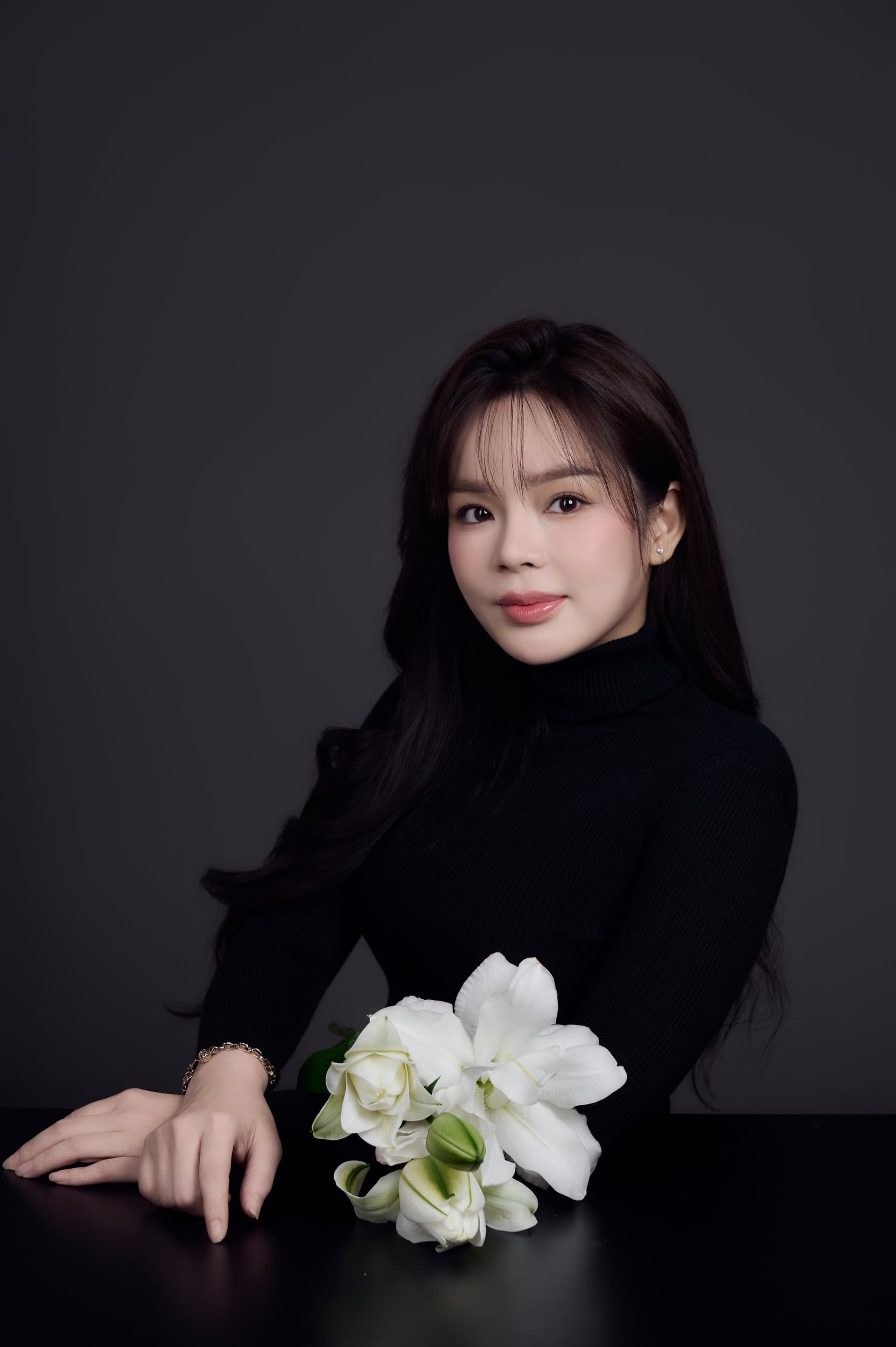 Phụ nữ ngồi với bó hoa trắng, ánh nhìn dịu, cô gái cũ trong mình vẫn còn