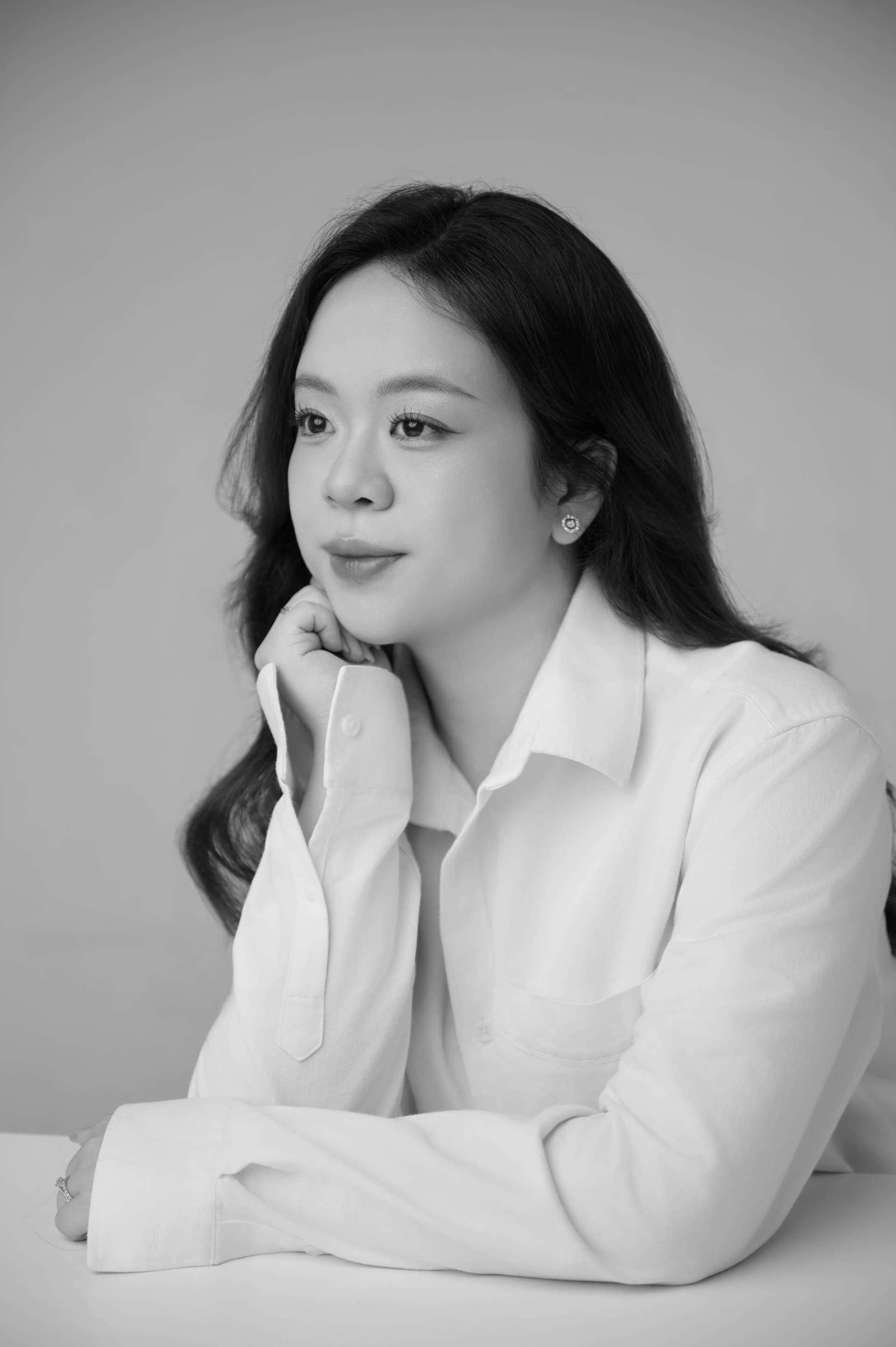 Phương Anh ngồi lặng im khẽ tựa cằm vào bàn tay, ánh mắt có chiều sâu lặng lẽ