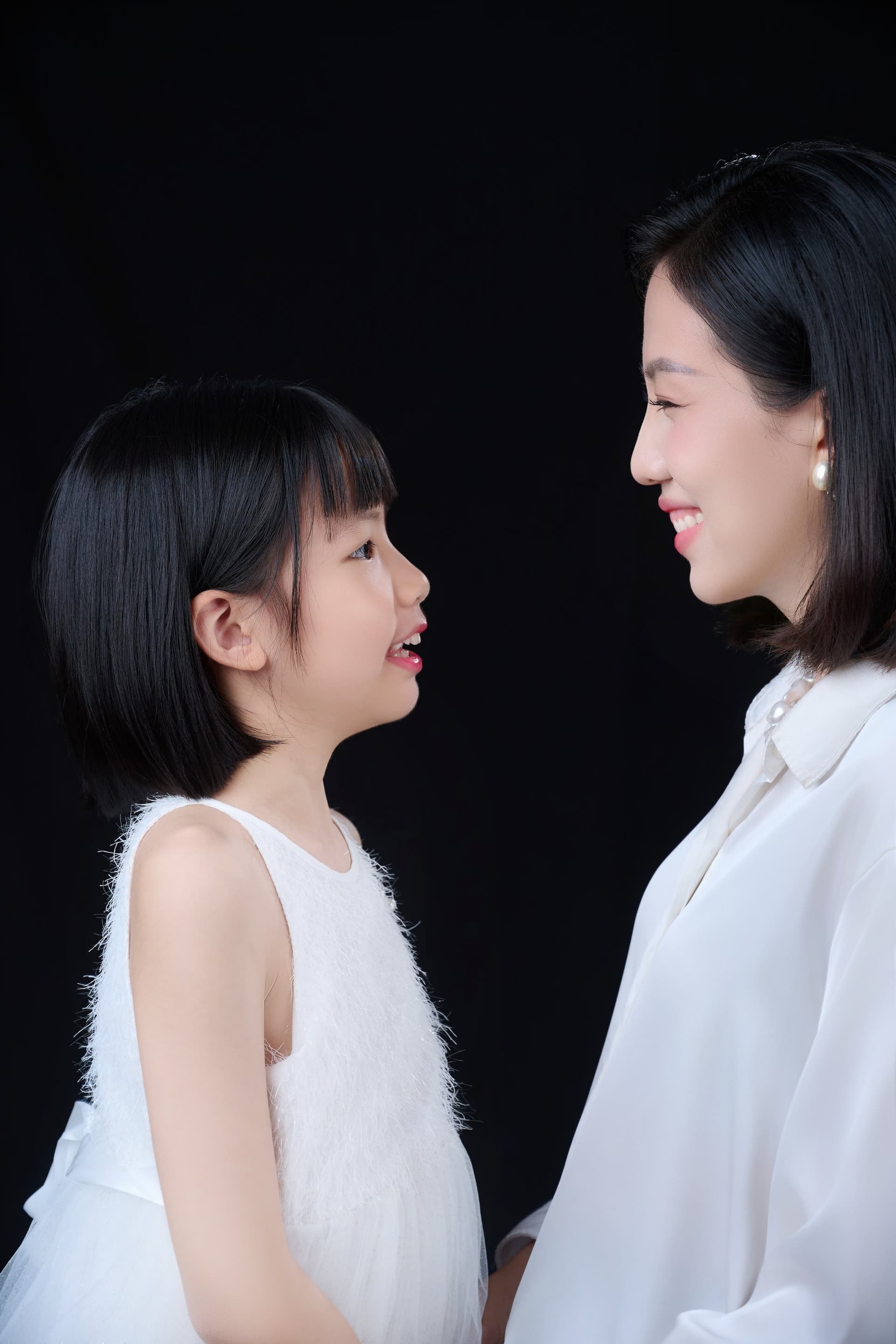 Người mẹ đứng cạnh con gái nhỏ, cả hai mặc áo trắng, ánh nhìn ấm — phần lớn thời gian của chị nằm trong gia đình