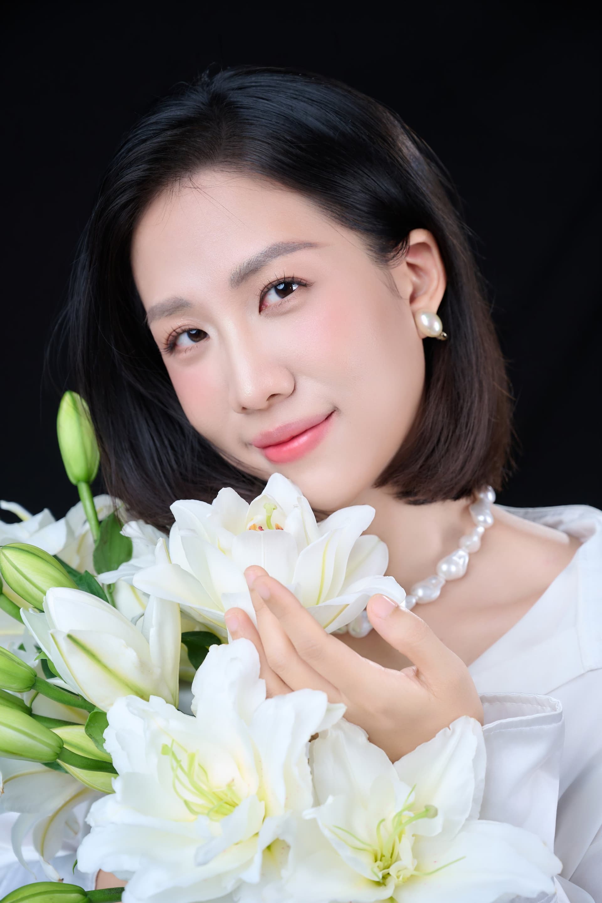 Chân dung người phụ nữ ngước nhẹ, ôm hoa, gương mặt sáng — phần vốn có trong chị lộ ra khi có thời gian riêng
