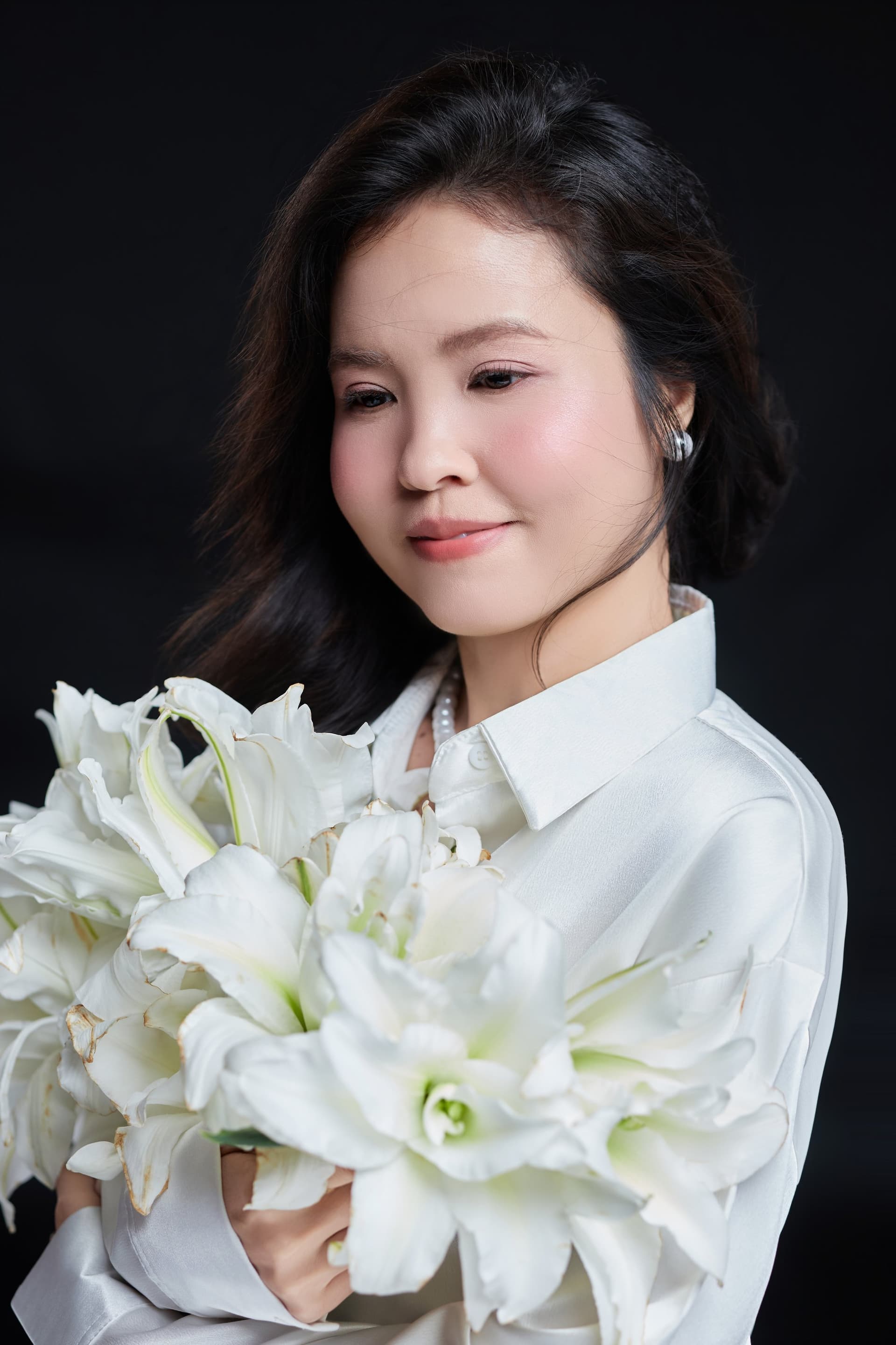 Lam dịu dàng ôm những nhành hoa ly trắng muốt, ánh nhìn bình yên tĩnh lặng
