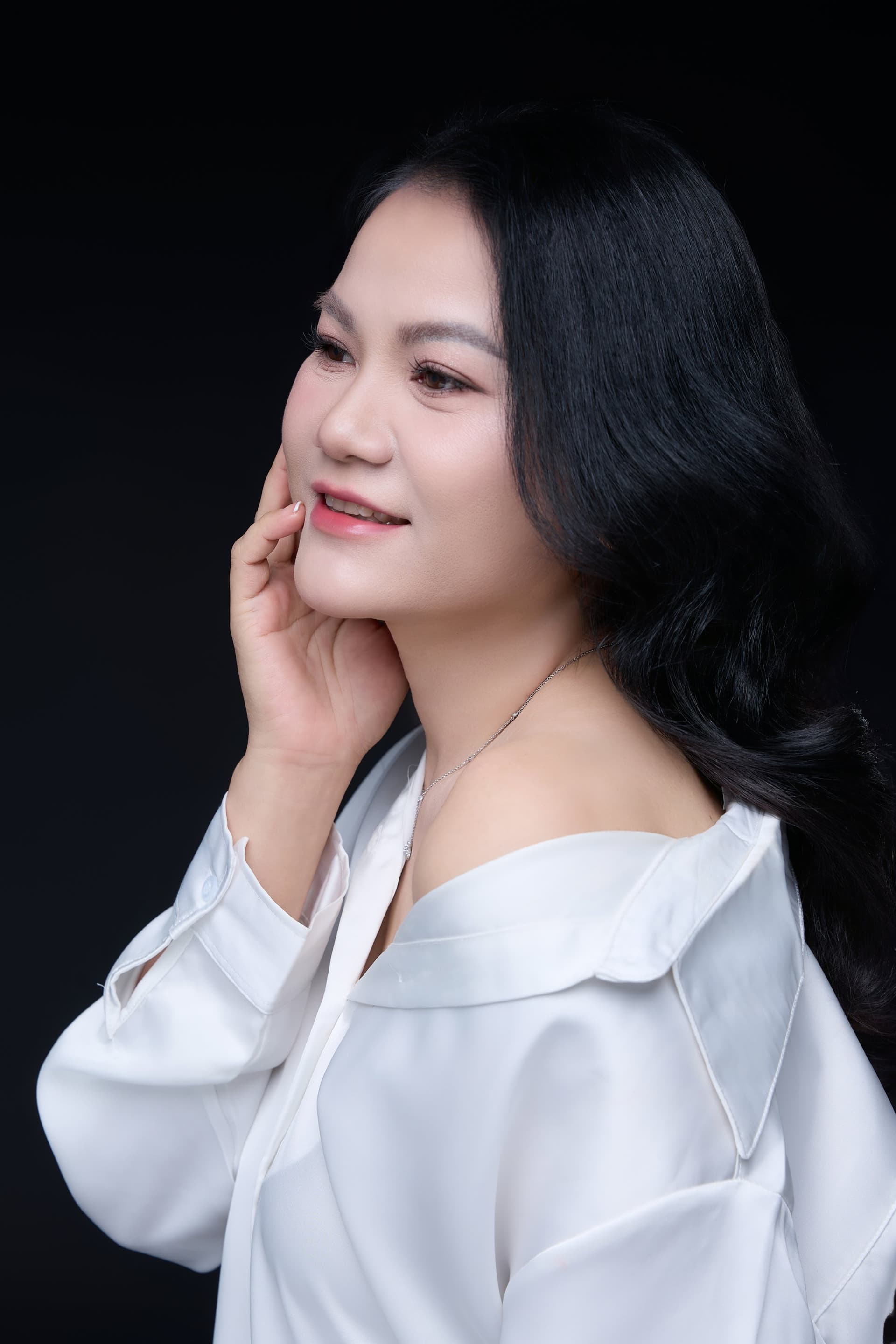 Chị Hà Nguyễn ngồi nghiêng người trầm tư tĩnh lặng, nét mặt suy tư nhẹ nhàng dịu dàng