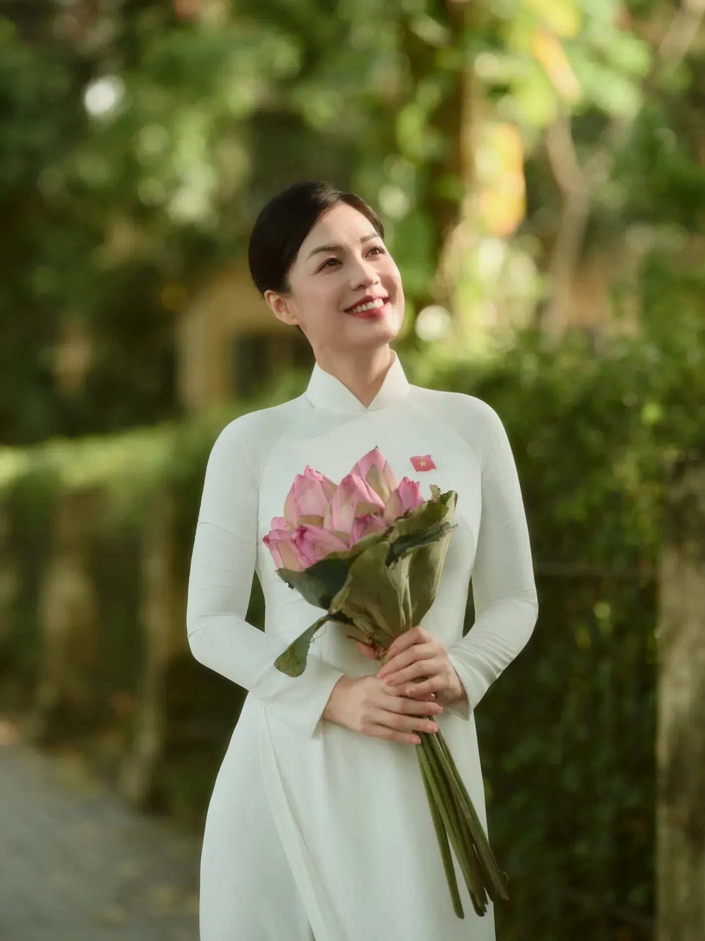 Áo dài trắng cầm hoa nhỏ cho concept mùa thu Hà Nội
