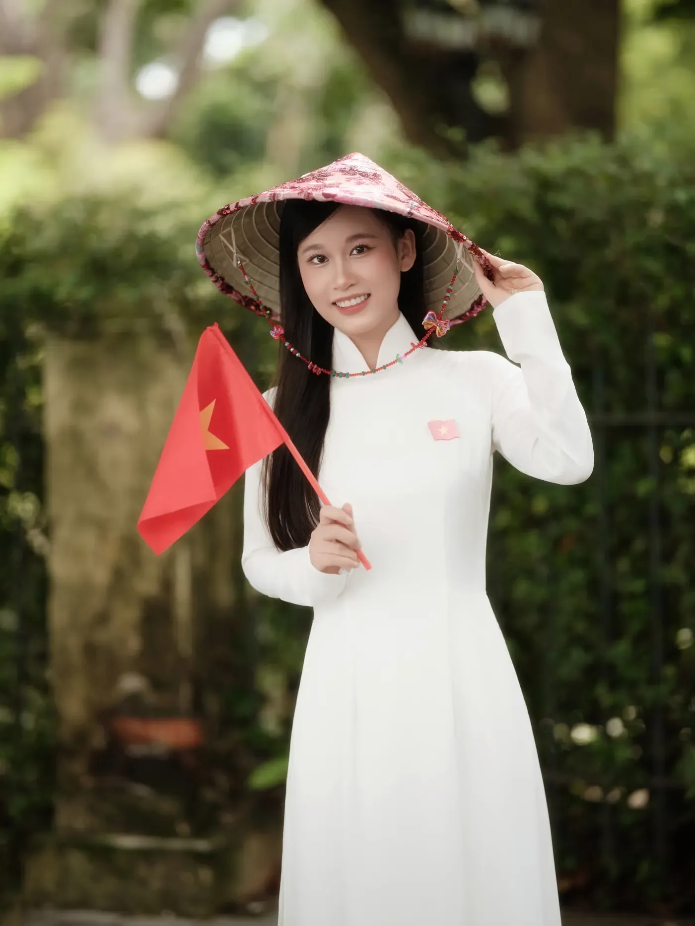 Áo dài trắng cầm cờ đỏ nhỏ trong concept Hà Nội mùa thu