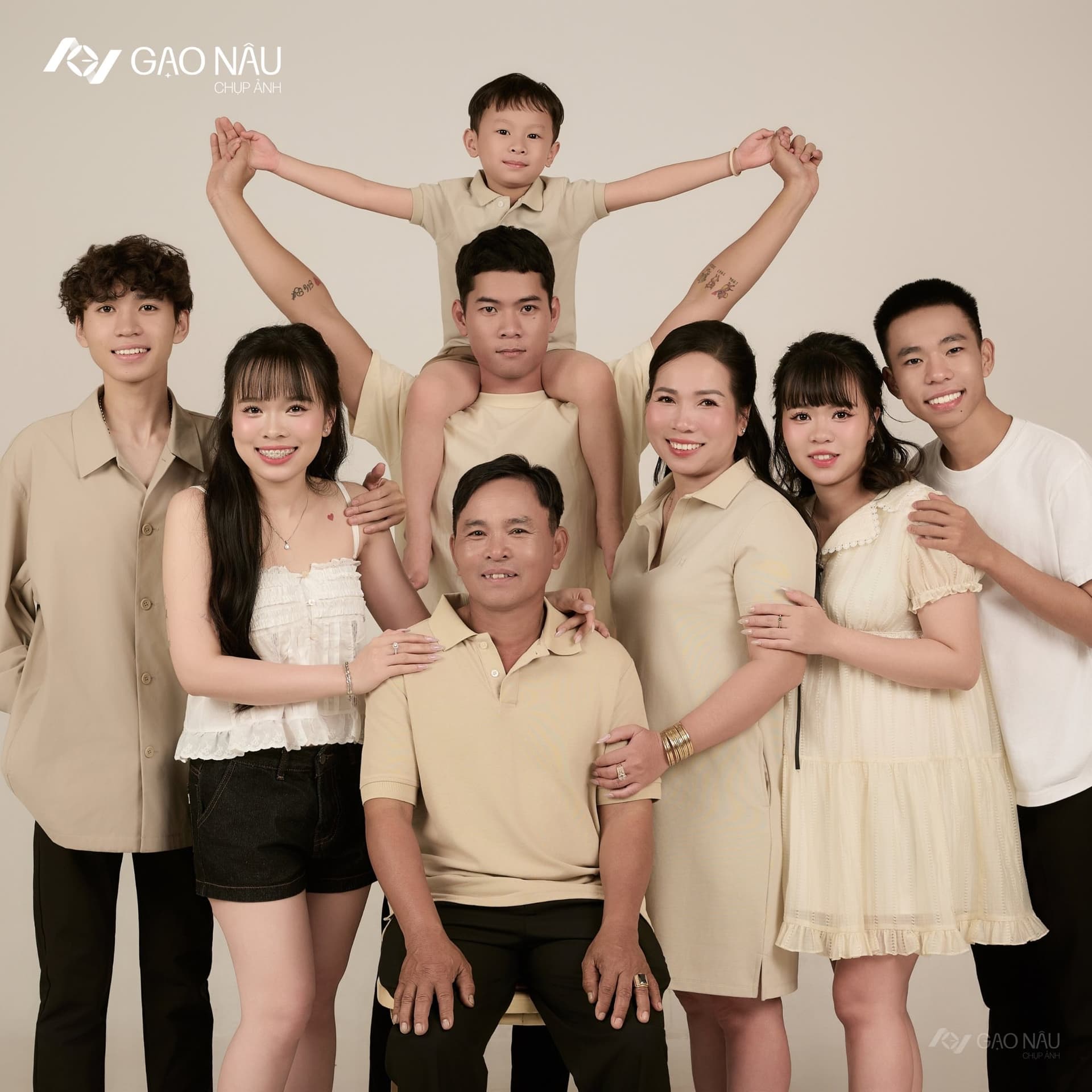 Gia đình chị chụp khoảnh khắc vui: bé trai ngồi trên vai anh lớn, cả nhà nắm tay giơ cao cùng cười