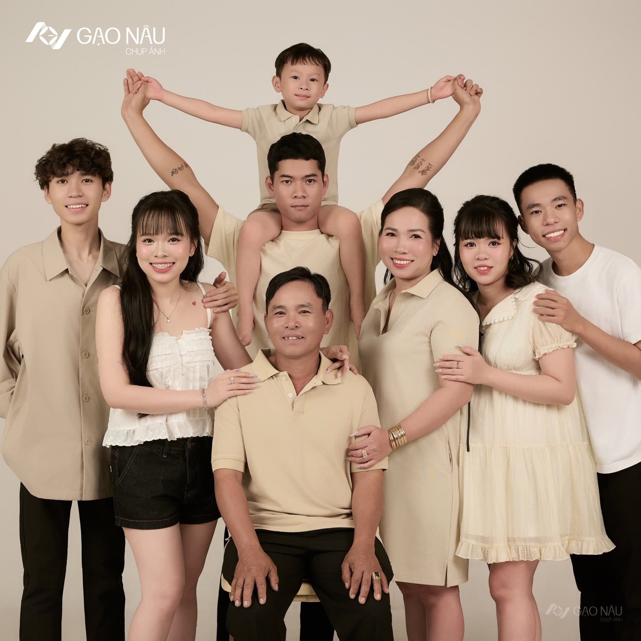 Gia đình chị chụp khoảnh khắc vui: bé trai ngồi trên vai anh lớn, cả nhà nắm tay giơ cao cùng cười