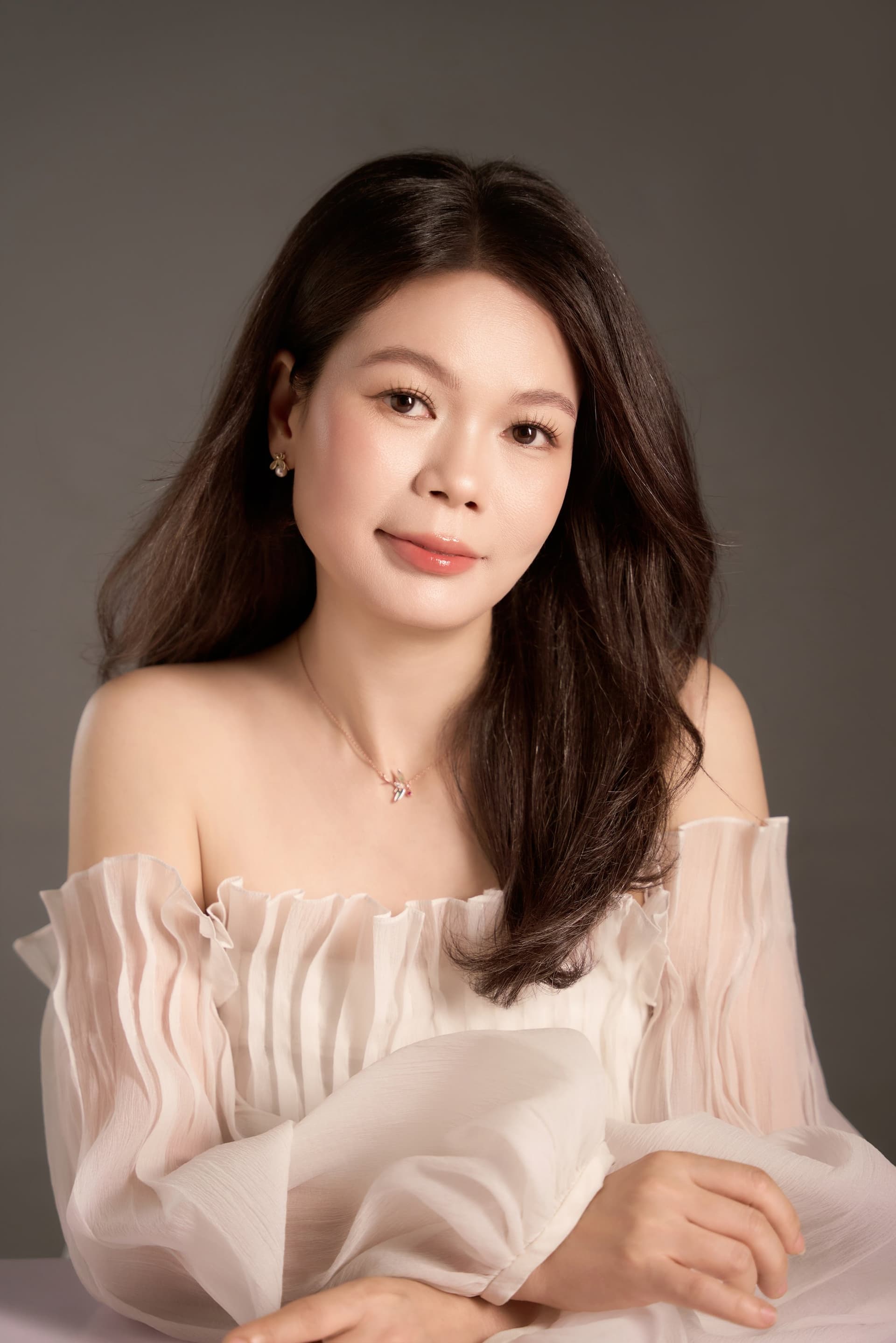 Vũ Huệ ánh nhìn dịu, vai trần áo nhẹ tone hồng phấn — chân dung mở đầu một ngày sinh nhật rất riêng của người phụ nữ đã có gia đình