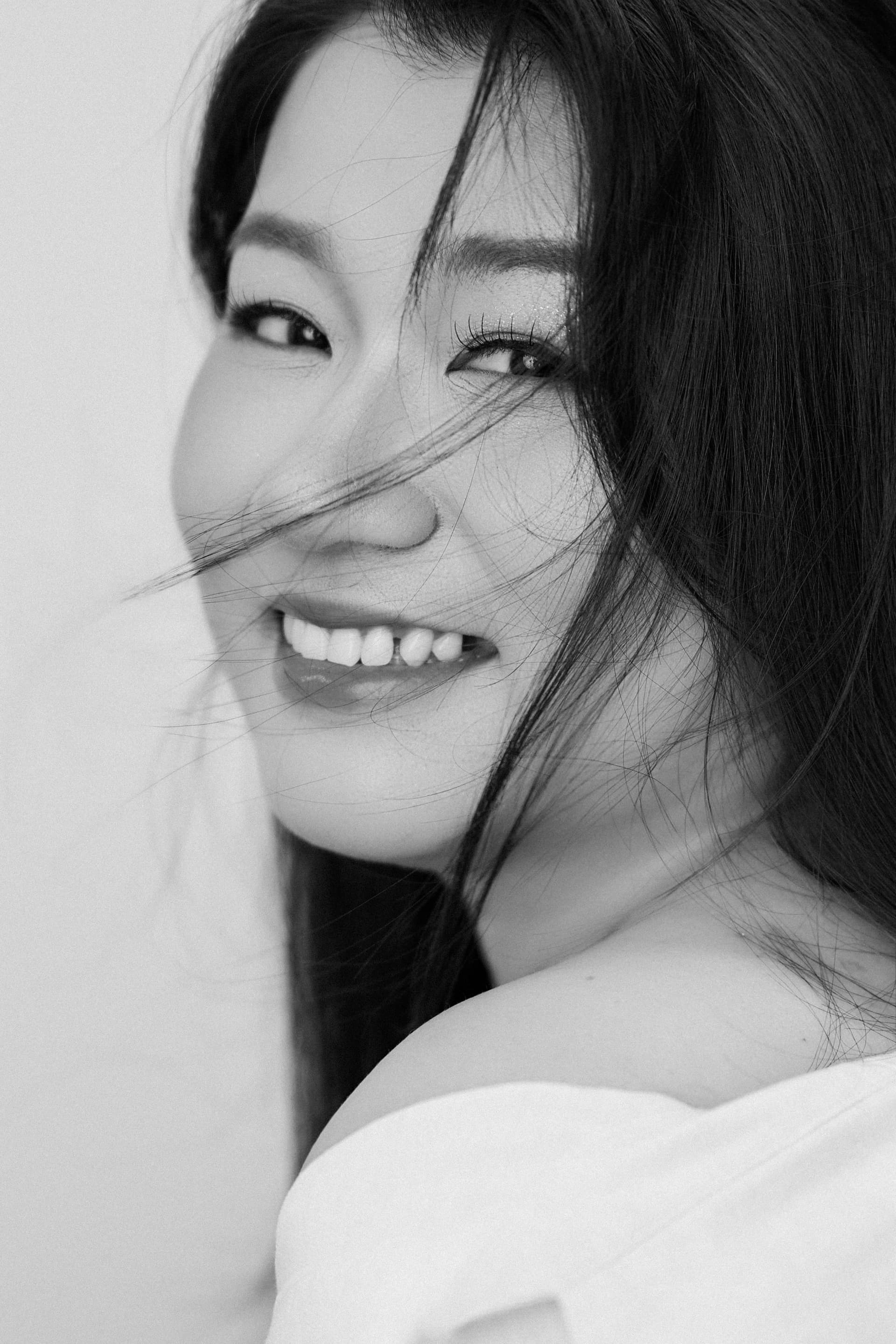 Side profile đen trắng, người phụ nữ cười nhẹ — tình yêu chuyển thành con và ở lại