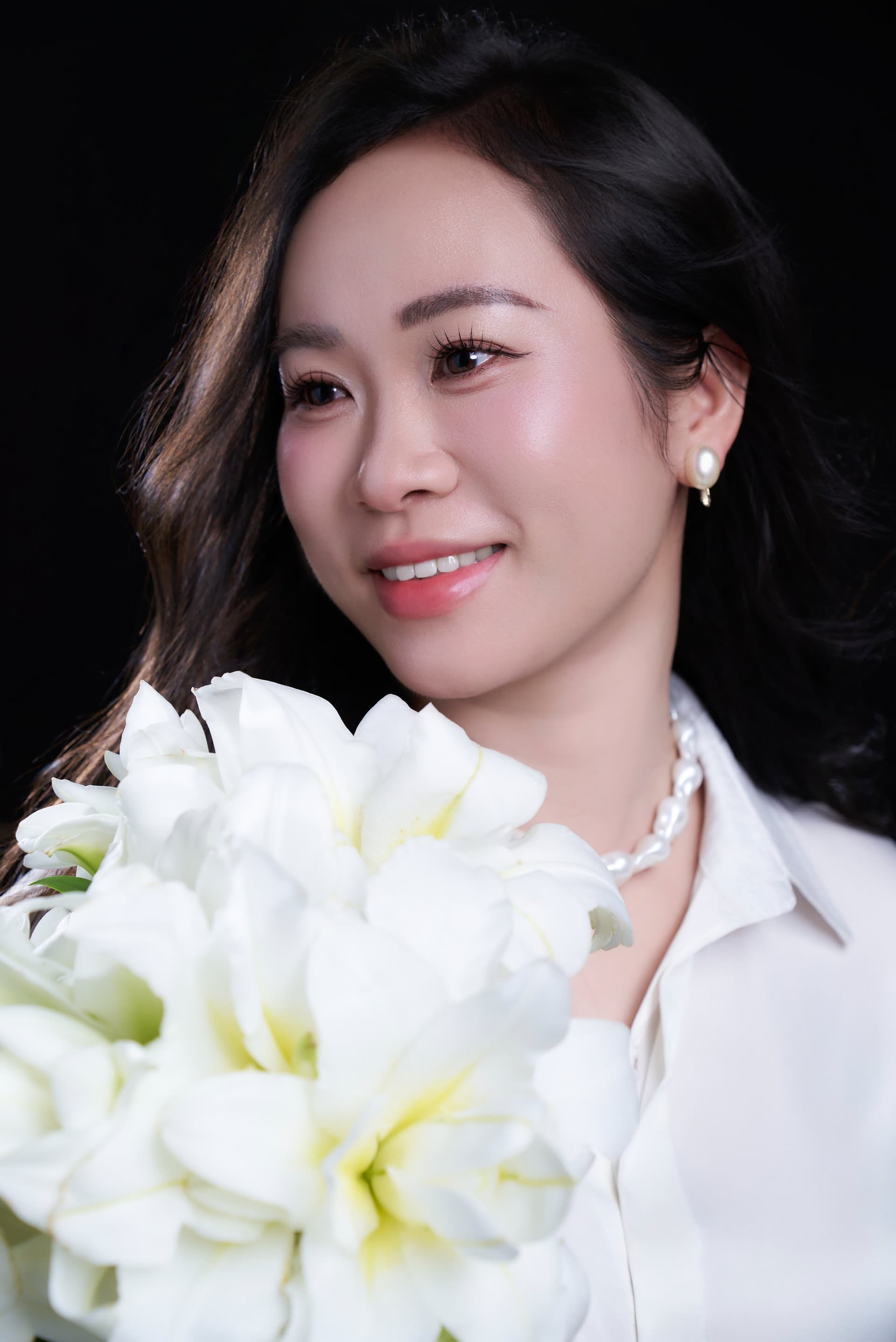 Chị Ngọc nhìn thẳng đầy tự tin, tay nâng niu những bông hoa trắng ngăn nắp và chỉn chu