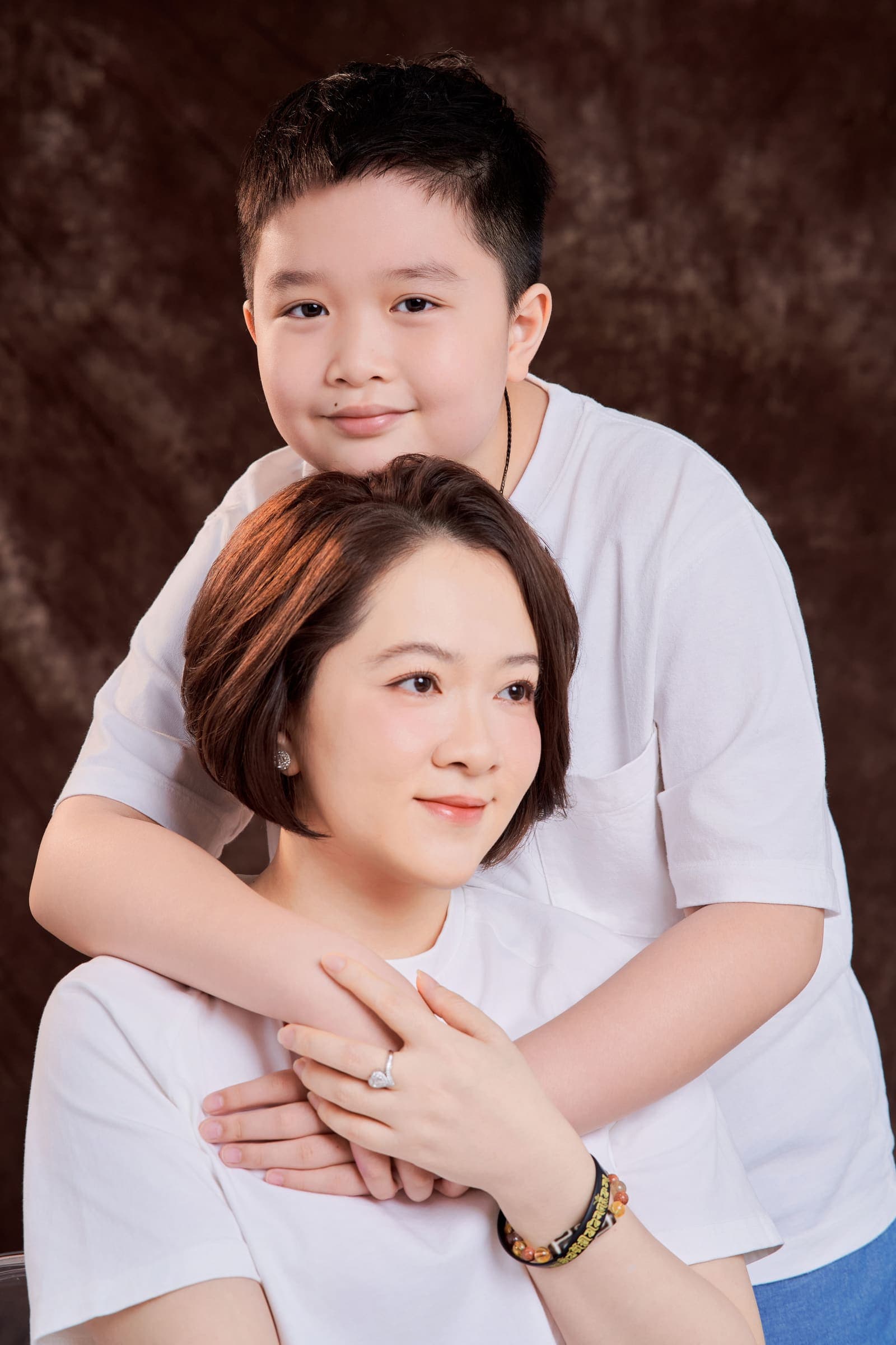 Mẹ và con trai đã lớn ngồi cạnh nhau — đôi dép đổi số, quần ngắn đi, giọng nói khác đi