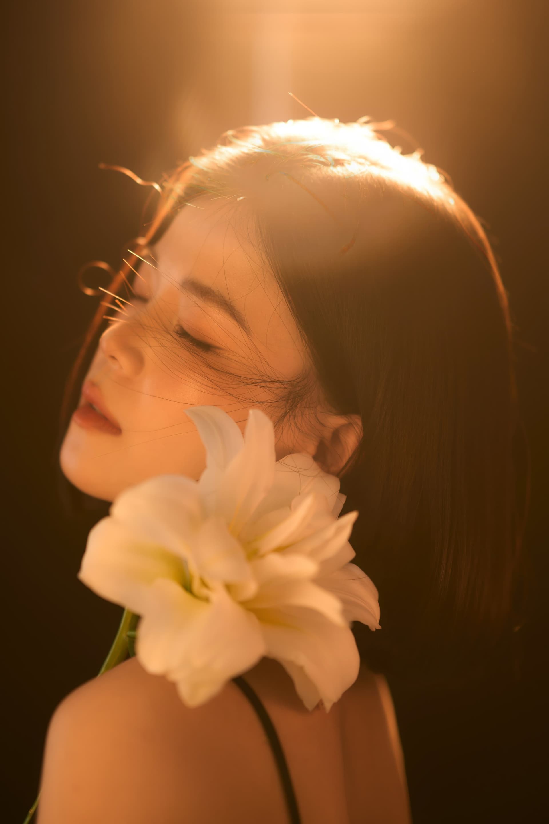 Phương Phạm khép mắt nhẹ nhàng bên nhành hoa trắng, đón nắng nhẹ rọi qua cửa sổ cùng làn tóc ngắn trẻ trung chạm vai