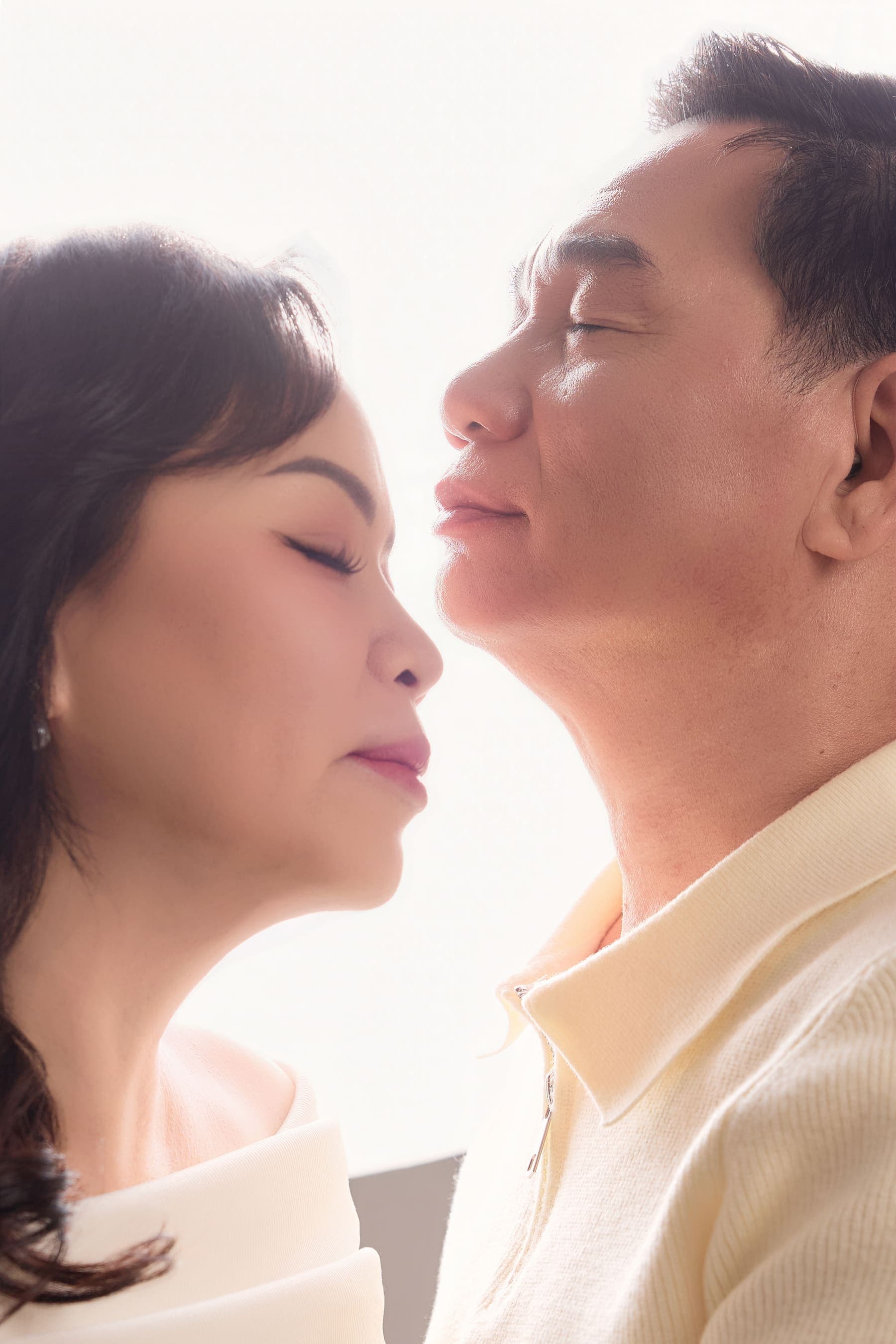 Hai gương mặt kề gần trong ánh sáng mềm, một khoảng lặng dịu của tình yêu lâu năm