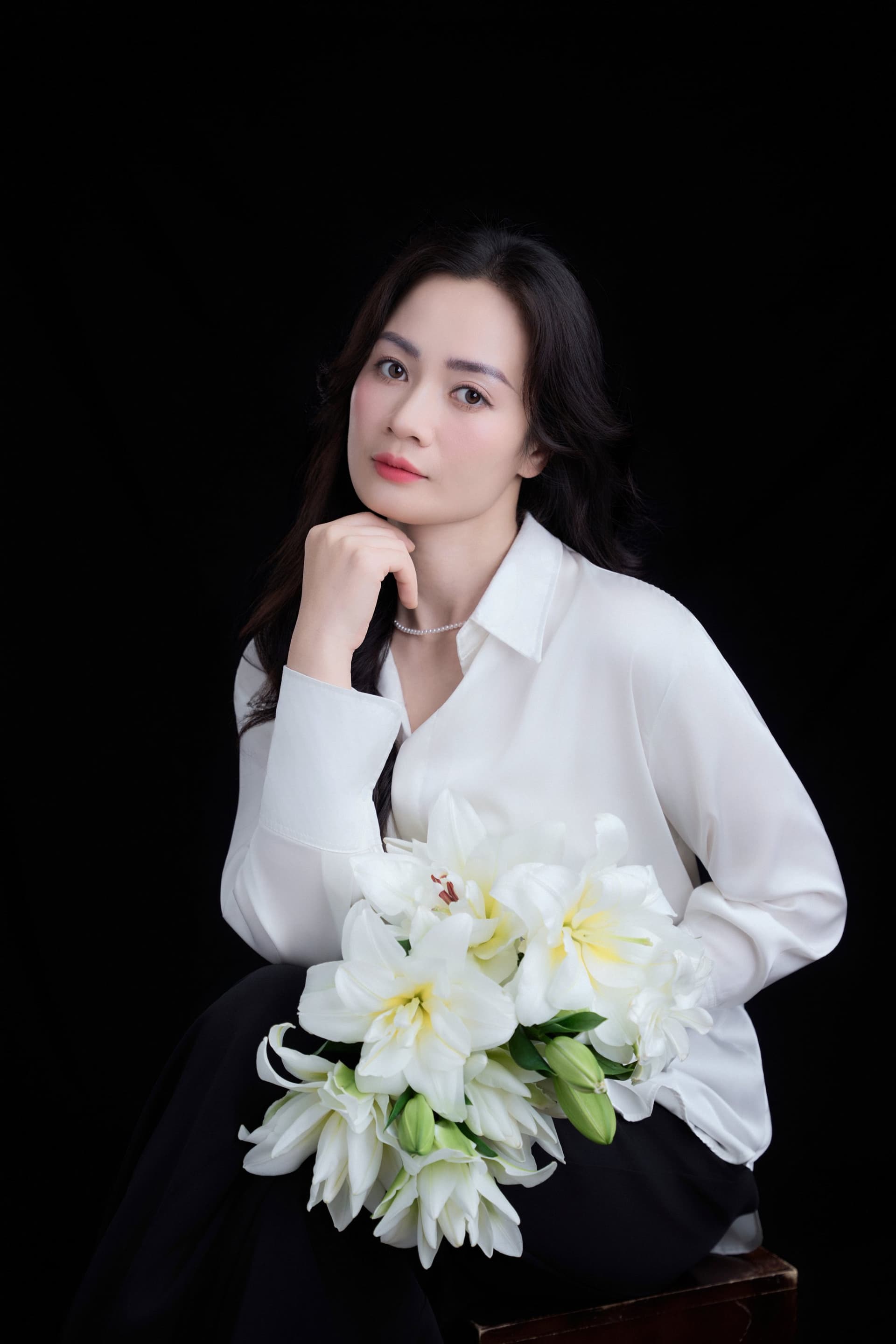 Chân dung chị Phương Thủy ngồi suy tư với góc nhìn chính diện, tựa cằm lên tay đầy trầm tĩnh