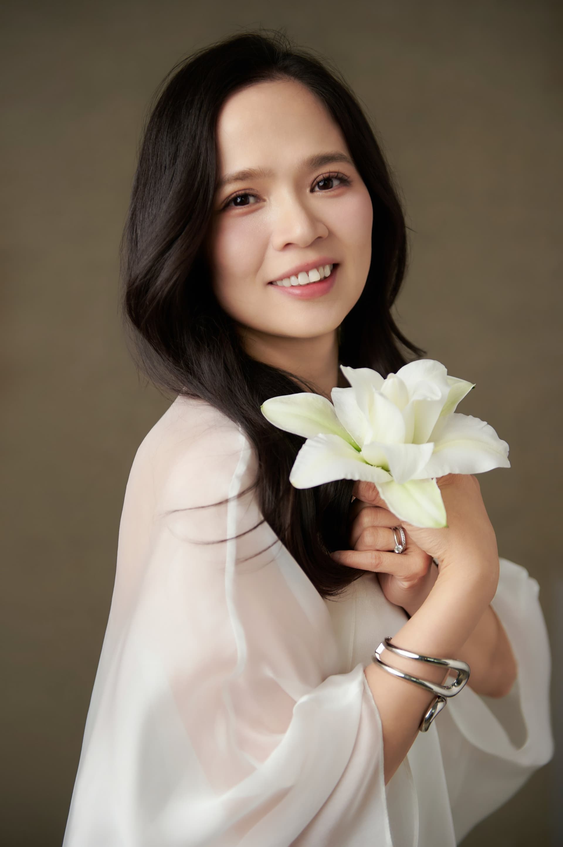 Mặt nghiêng cười dịu — gương mặt nhớ rằng trước khi là mẹ, mẹ cũng từng là một người phụ nữ