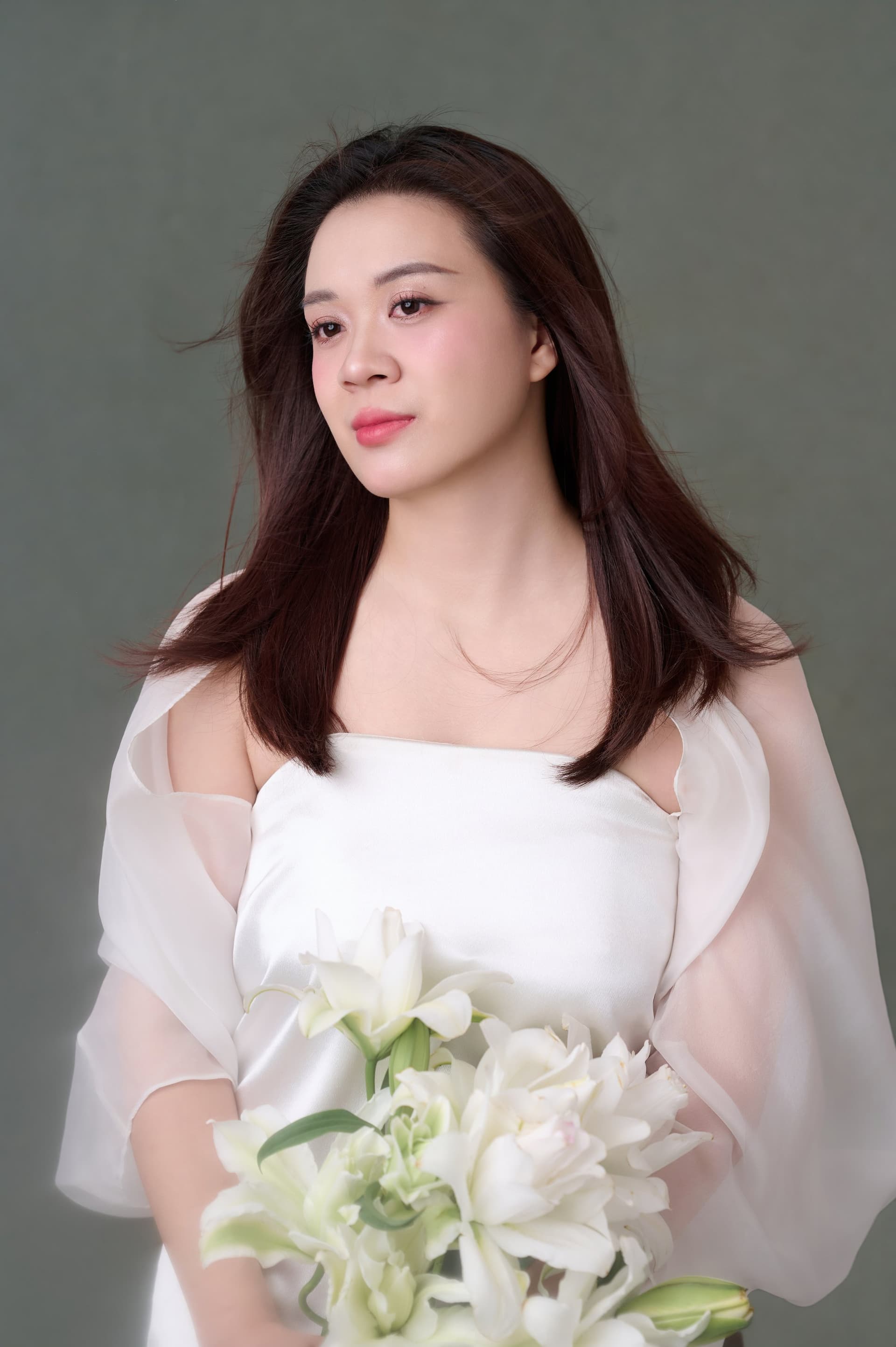 Người phụ nữ mỉm cười dịu bên bó hoa trắng, khoảnh khắc gặp lại chính mình