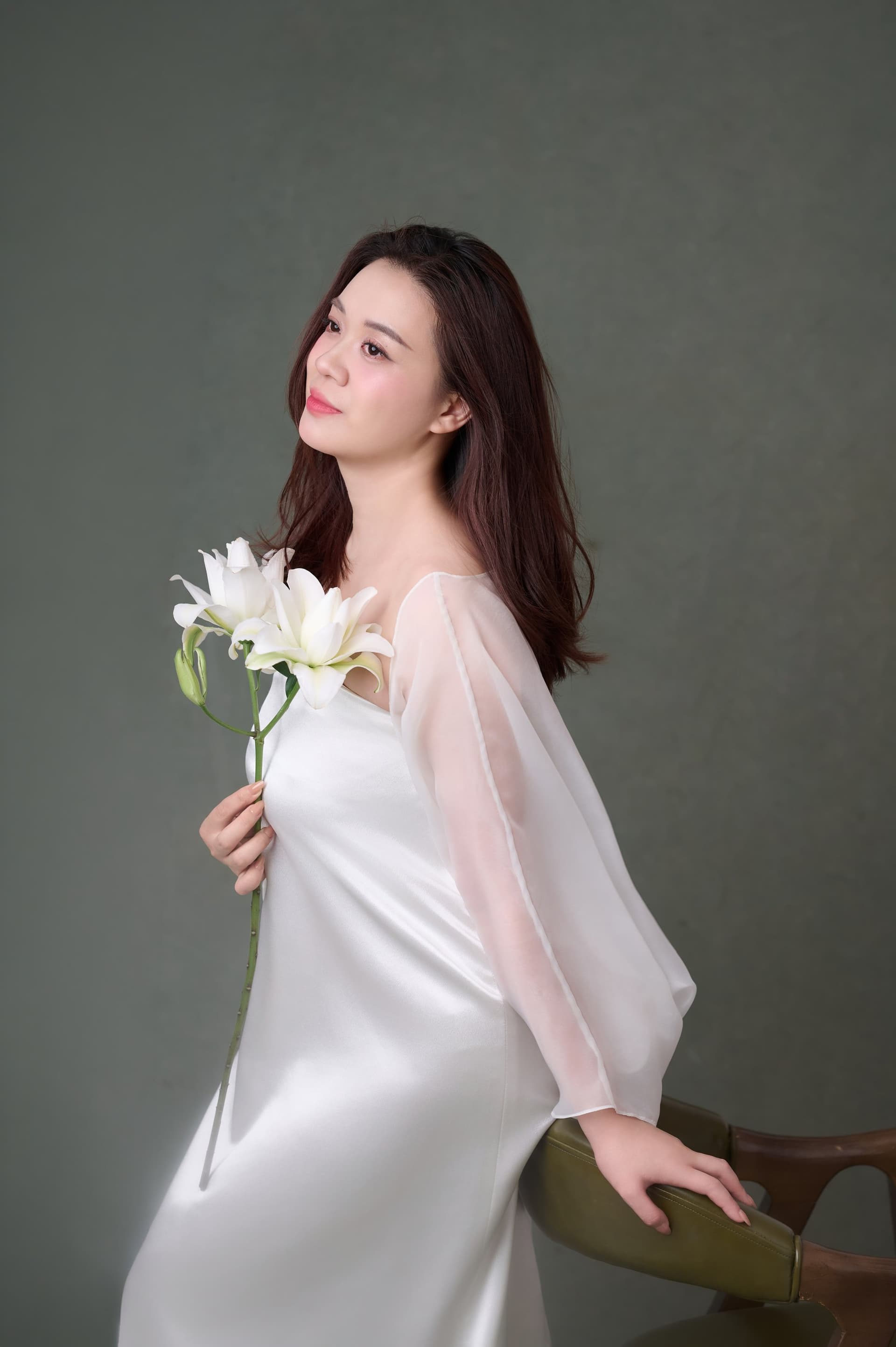 Chân dung phụ nữ áo trắng giữa nền dịu, dáng người trẻ trung trở về