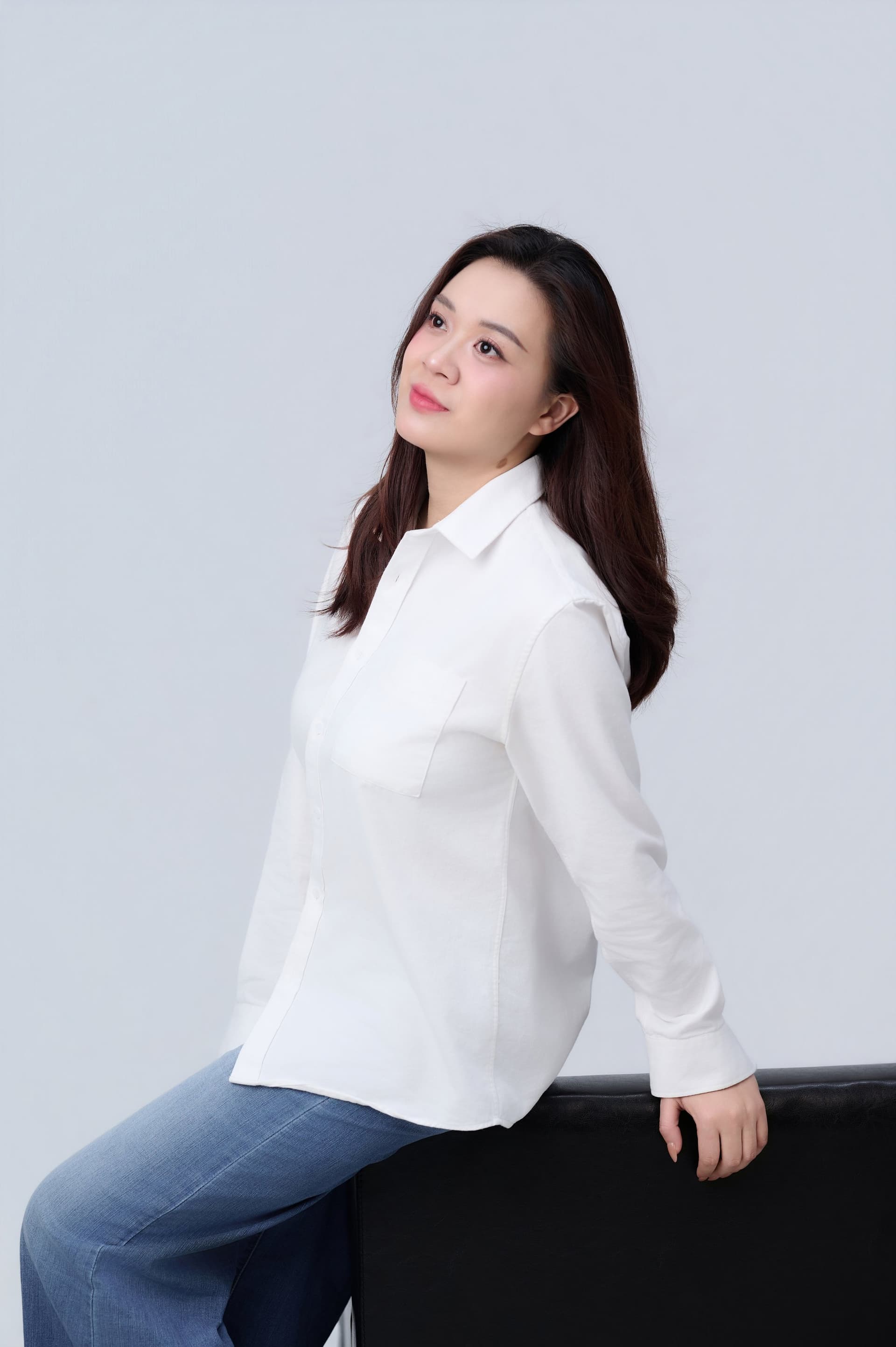 Người phụ nữ áo trắng ngồi yên, dáng người tự một mình trong khoảng lặng