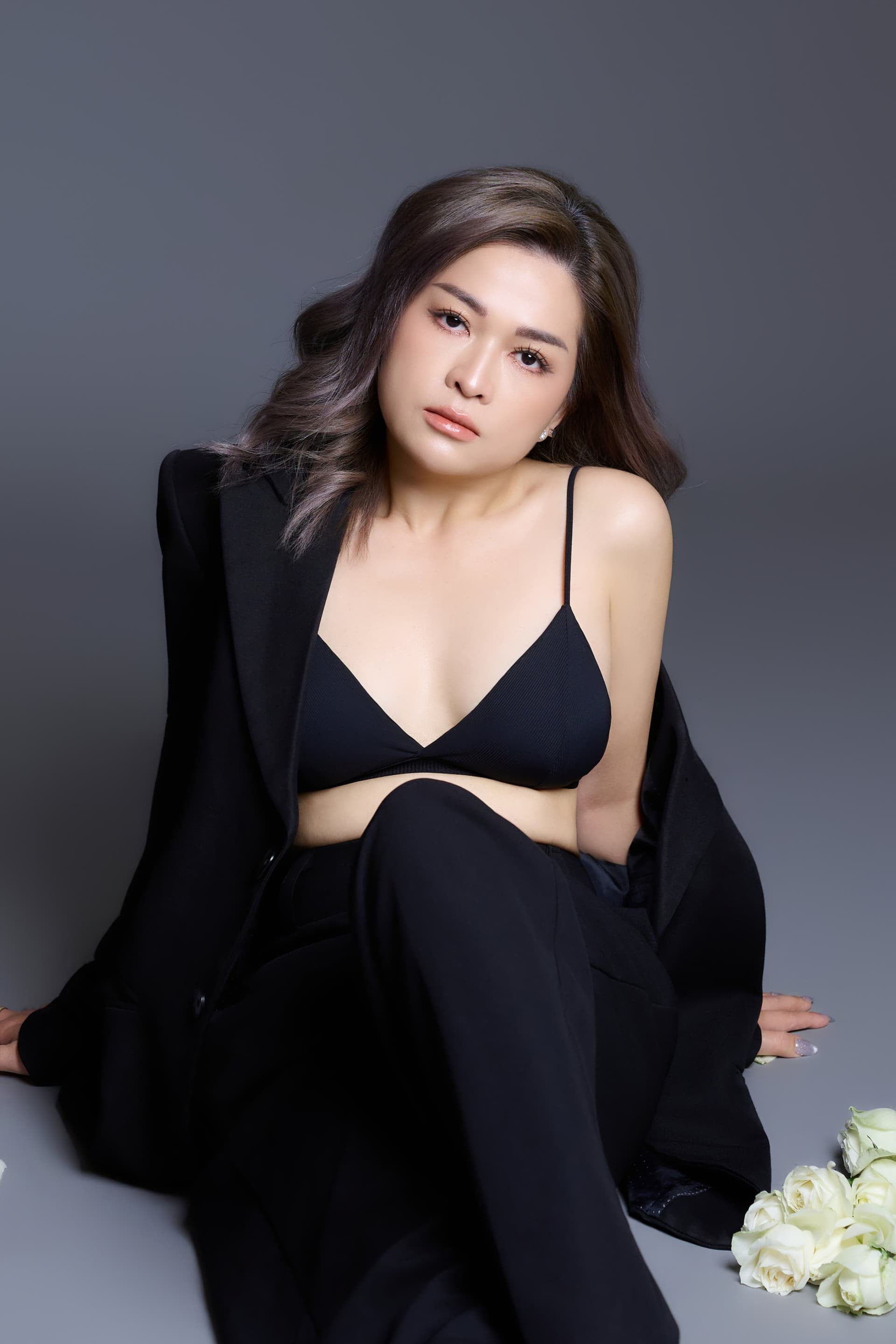 Người phụ nữ đứng ôm bó hoa trắng, suit hở — khoảnh khắc một lần không chờ nữa, làm điều cho riêng mình