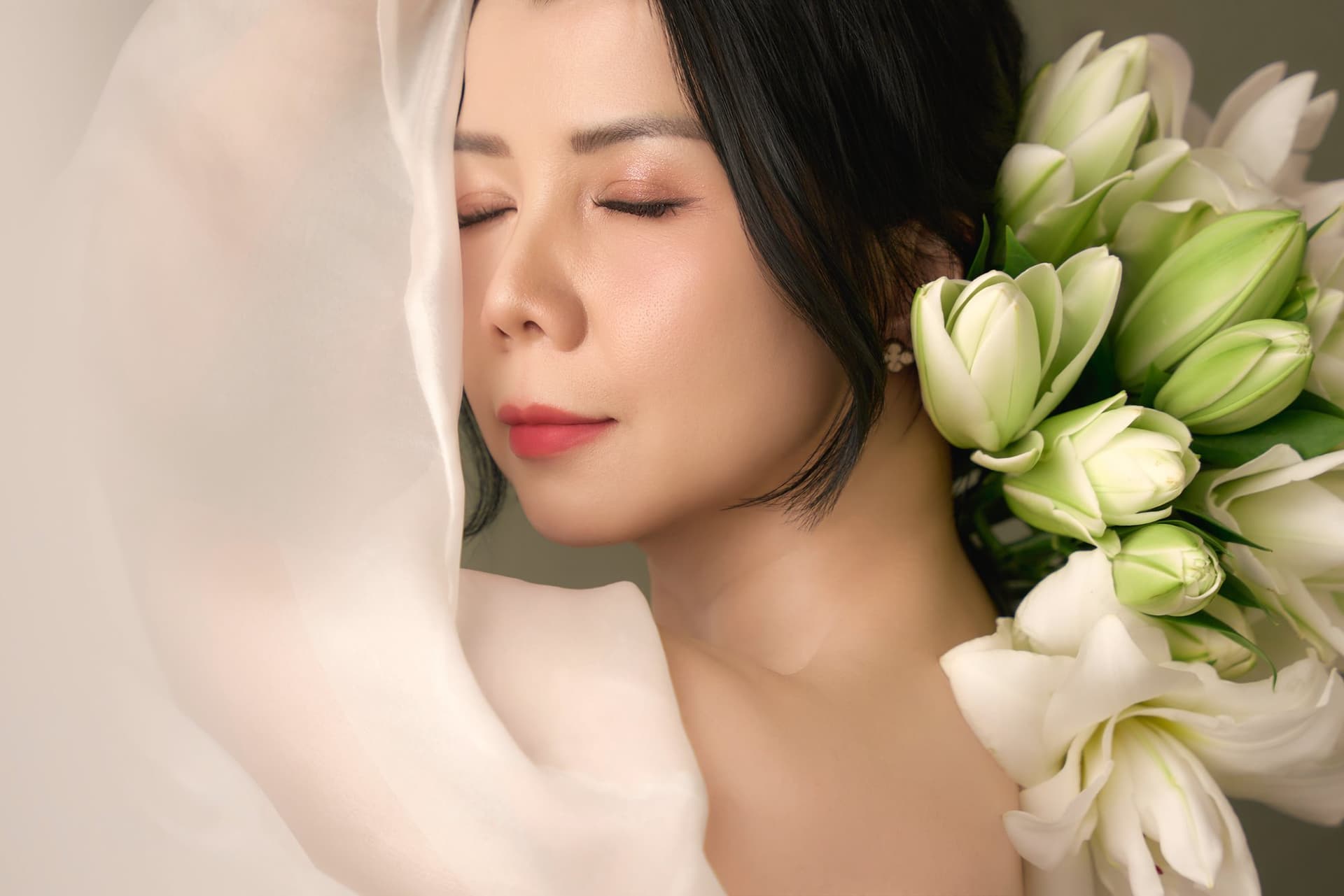 Chị Thanh Nhài nhắm mắt nhẹ nhàng, tựa gương mặt bên đóa hoa ly trắng muốt trong màn voan mờ ảo