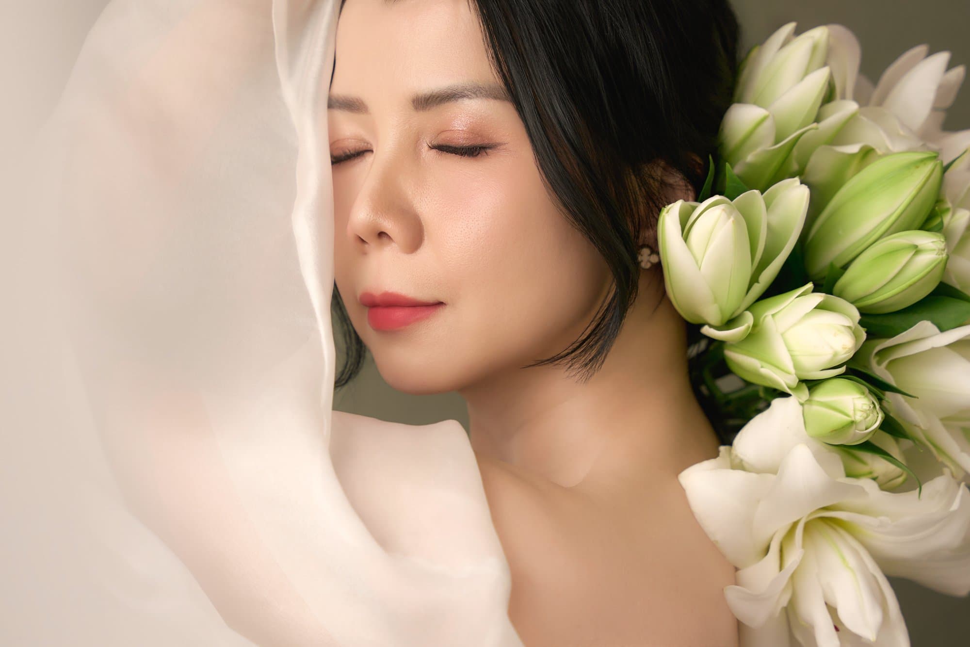 Chị Thanh Nhài nhắm mắt nhẹ nhàng, tựa gương mặt bên đóa hoa ly trắng muốt trong màn voan mờ ảo