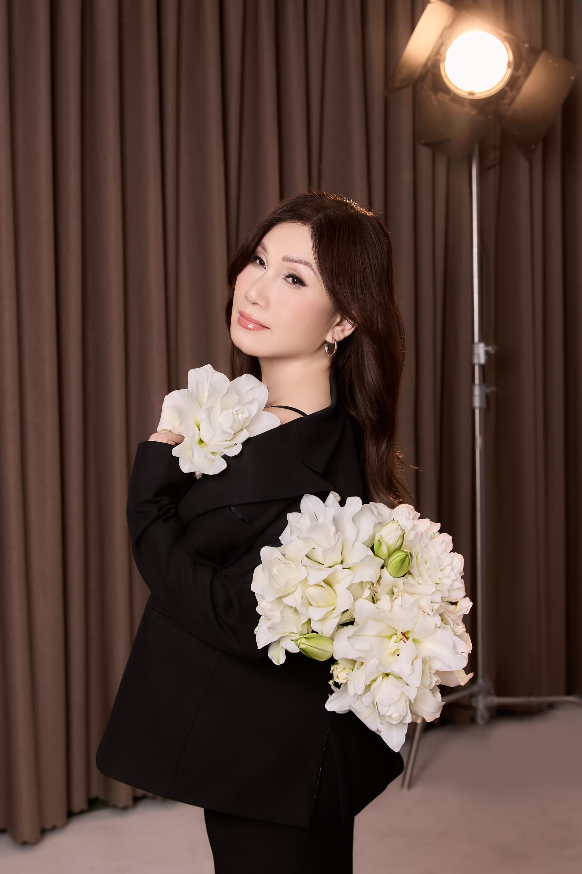 Mẹ tựa đầu khẽ nhìn xuống với bó hoa trắng cùng nụ cười duyên dáng thanh lịch